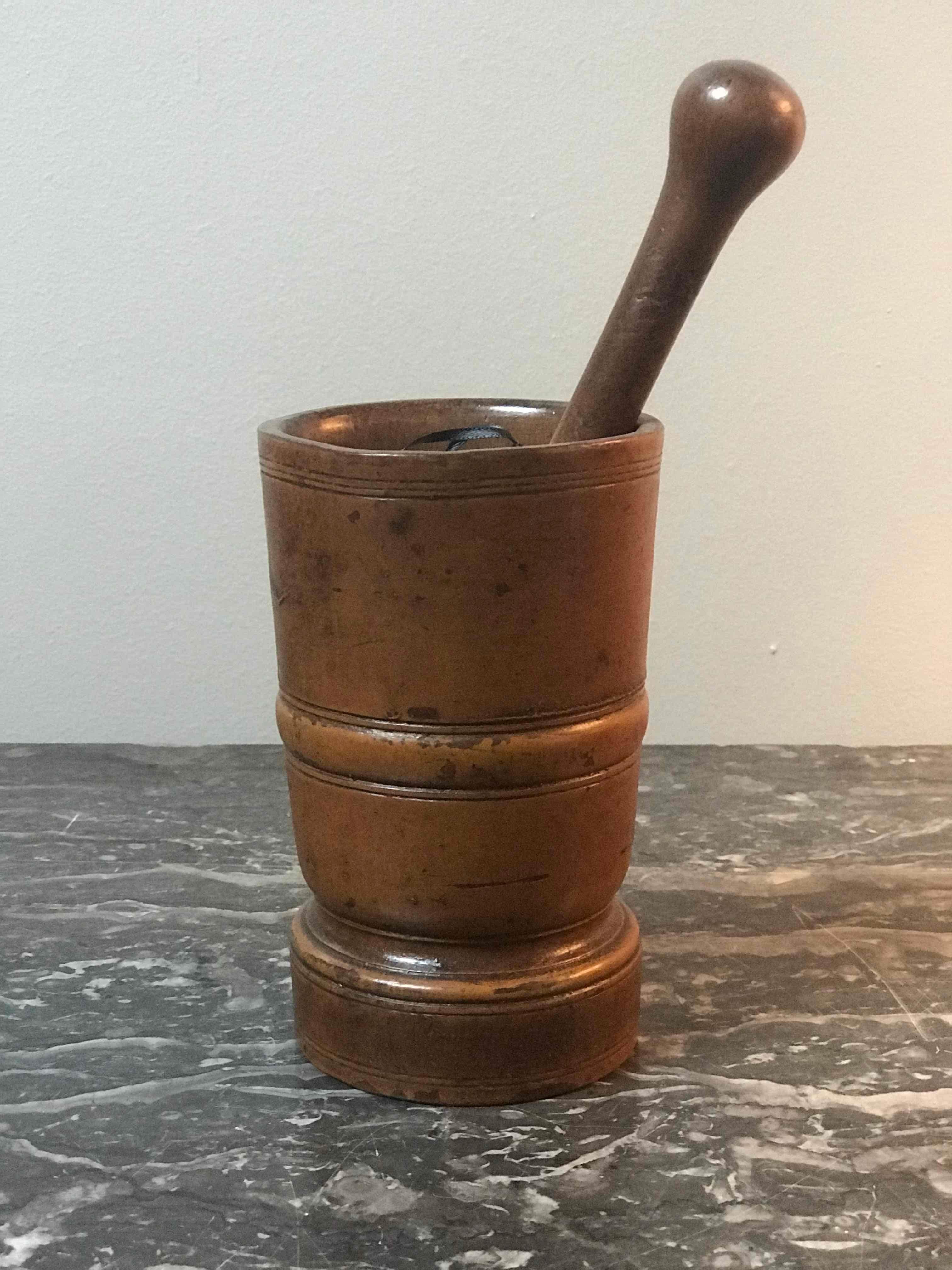 A mortar and pestle carved from wood with banding detail. Originating from France c. 1880. 