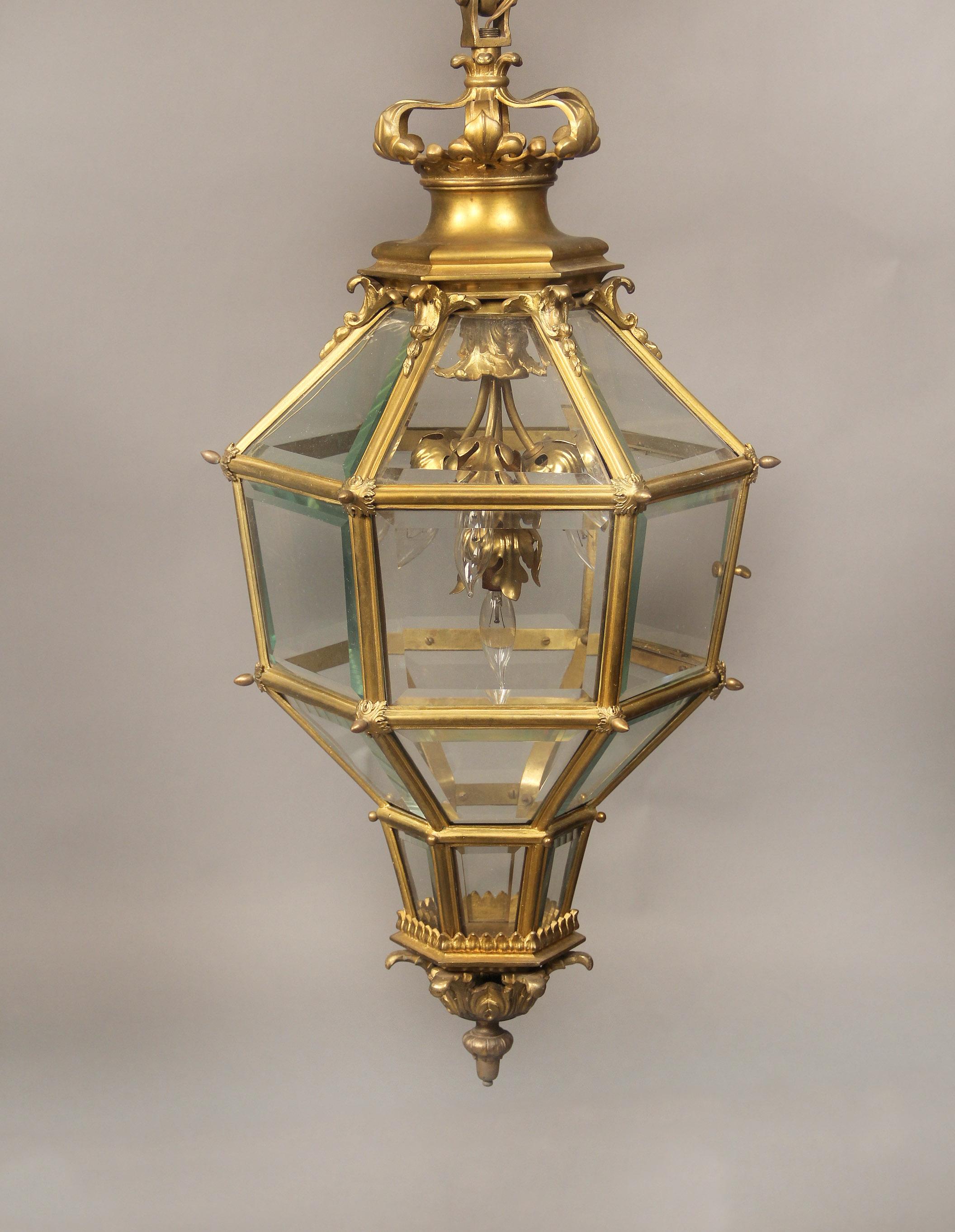 A late 19th/Early 20th century gilt bronze and glass ‘Versailles’ Hall Lantern.

After the Versailles model, of hexagonal and cage form with a fleur de lis corona top, four interior lights.