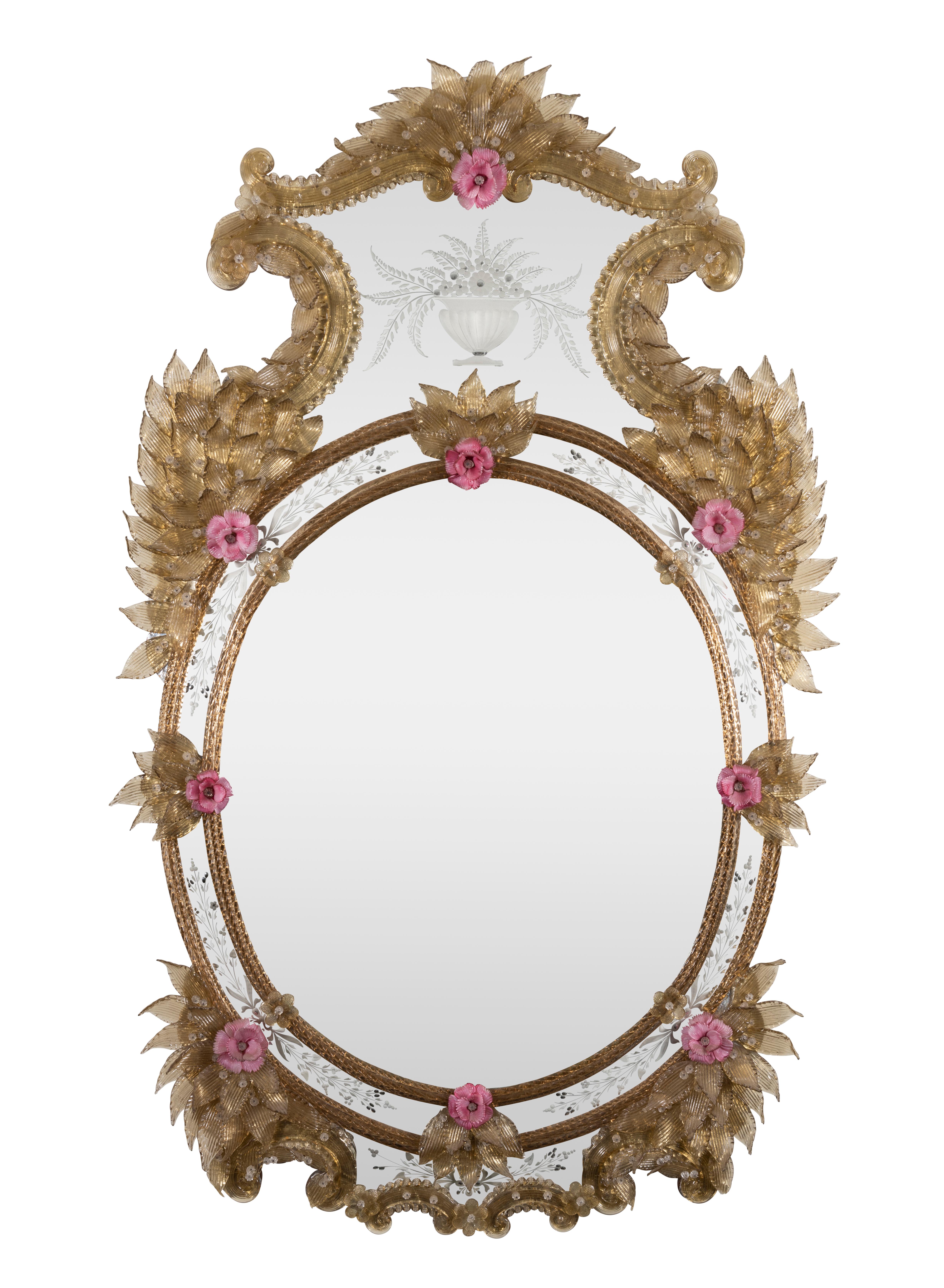 A Late 19th Venetian Oval Gilt-Inlaid, Coloured Glass and Etched Mirror

The high shaped crest framed by opposed C scrolls and S scrolls with overlapping leaves above, the glass centred by a gadrooned vase of foliage and flowers, the shoulders with