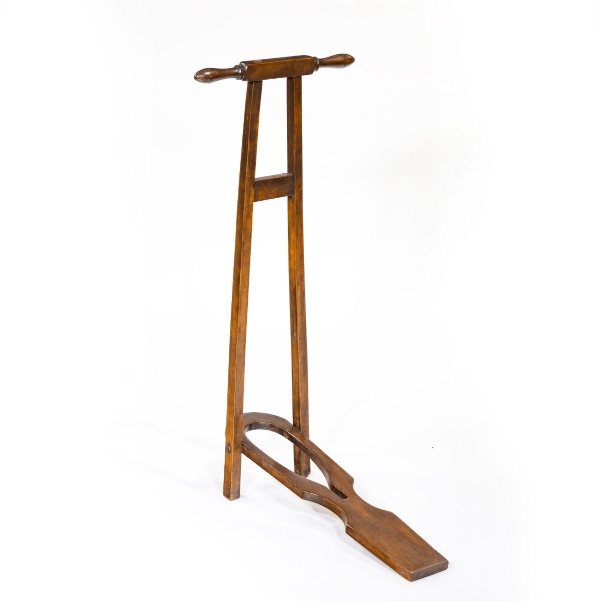 A late George III mahogany boot jack, the A-frame with two handles and a hinged boot pull, English, circa 1810.
  
