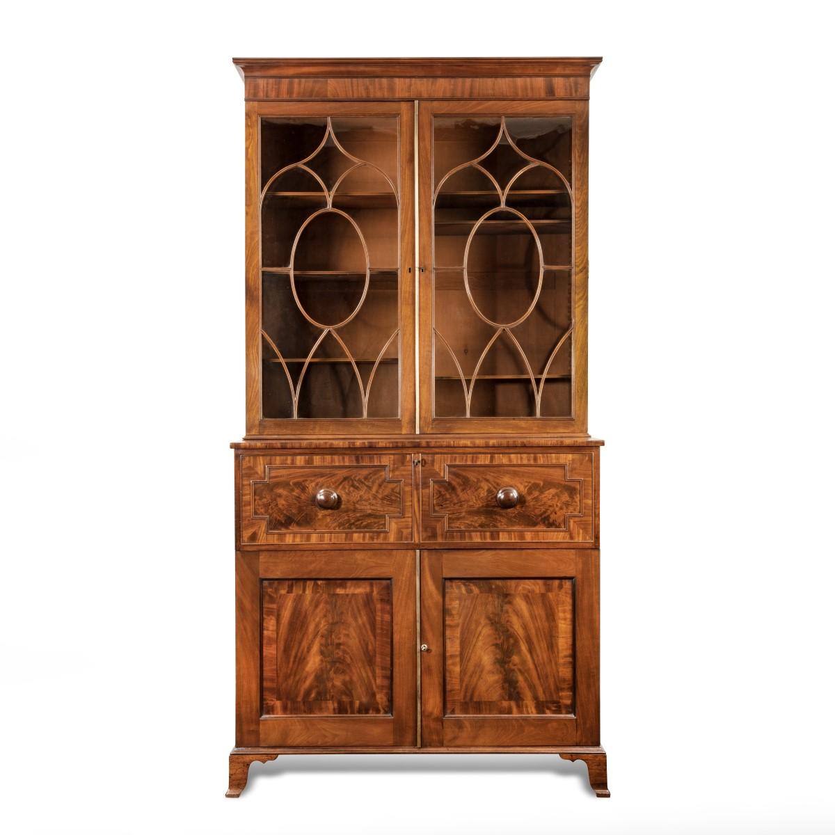 A late George III mahogany secretaire bookcase attributed to Gillows, of tall rectangular form with a secretaire drawer with a leather-inset fall front enclosing four shaped pigeonholes and small drawers flanking central compartment, all above two