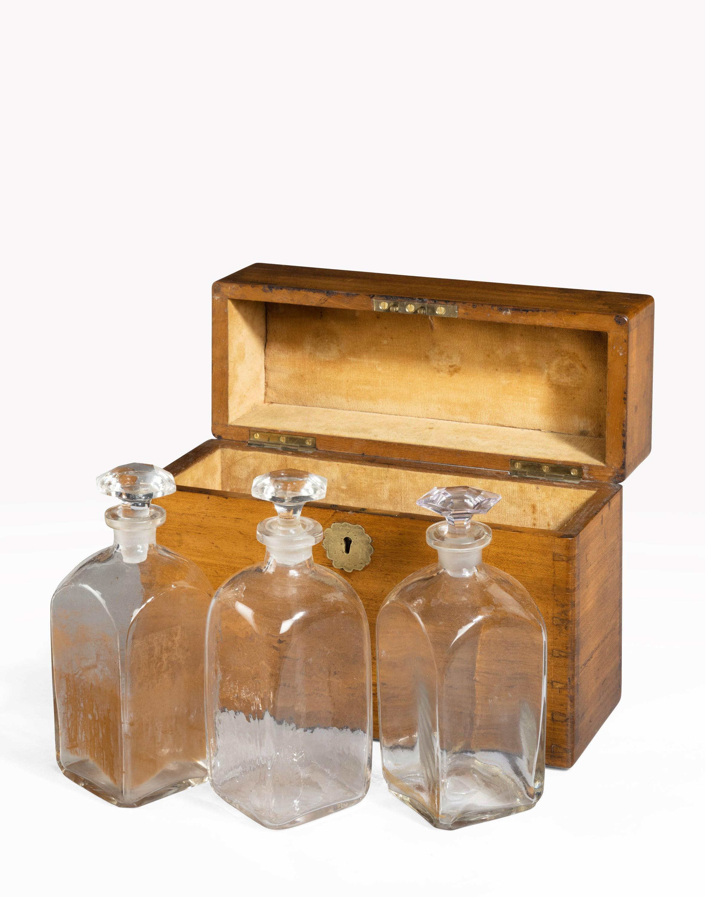 A late George III period travelling box retaining three period decanters. Finely finished tongue and groove corners.
  