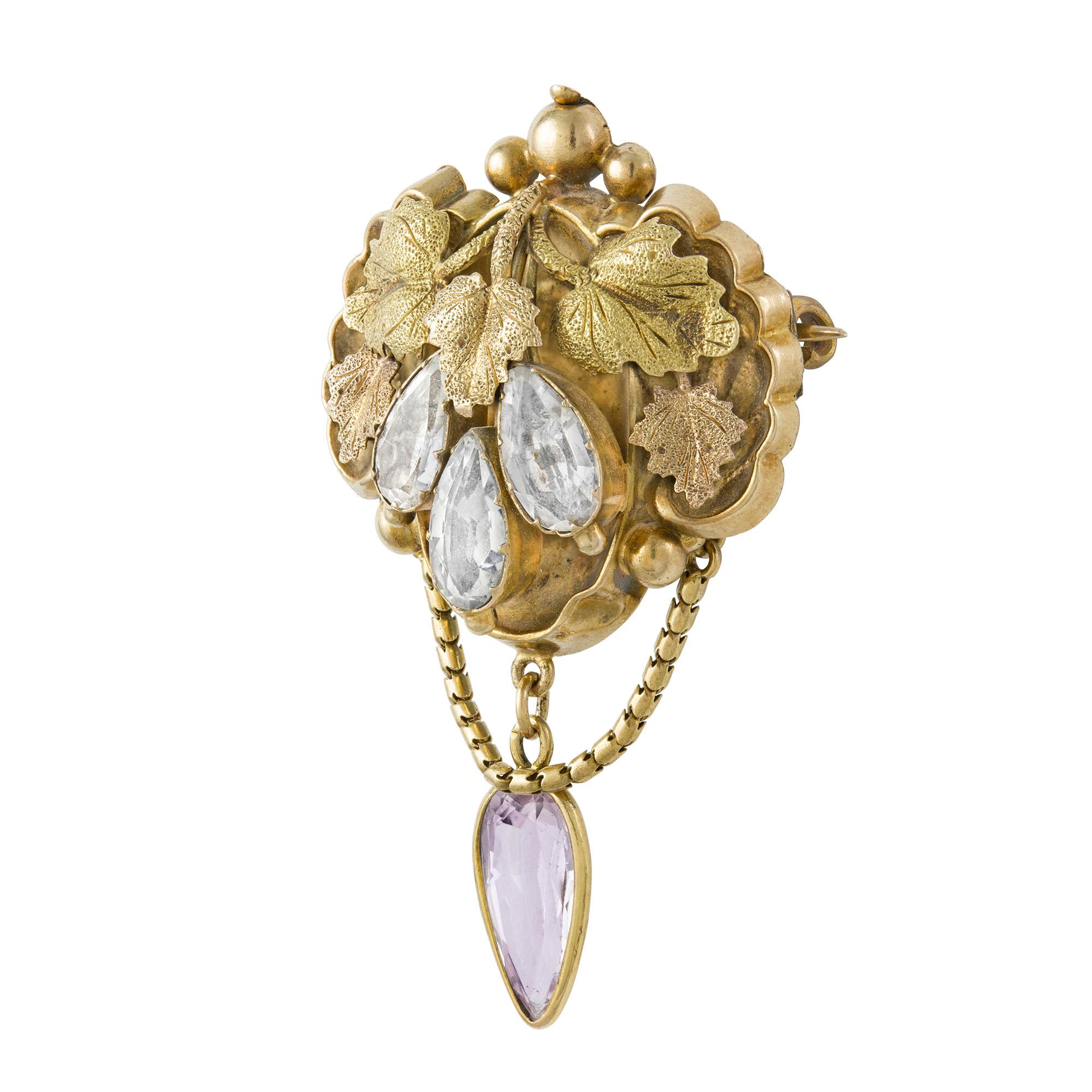 A late Georgian gold and gemset brooch, the brooch comprising ornately-carved foliate motifs in yellow and rose gold, set with three pear-shaped blue topaz and suspending a pear-shaped pink topaz drop, all set in yellow gold to a closed back and