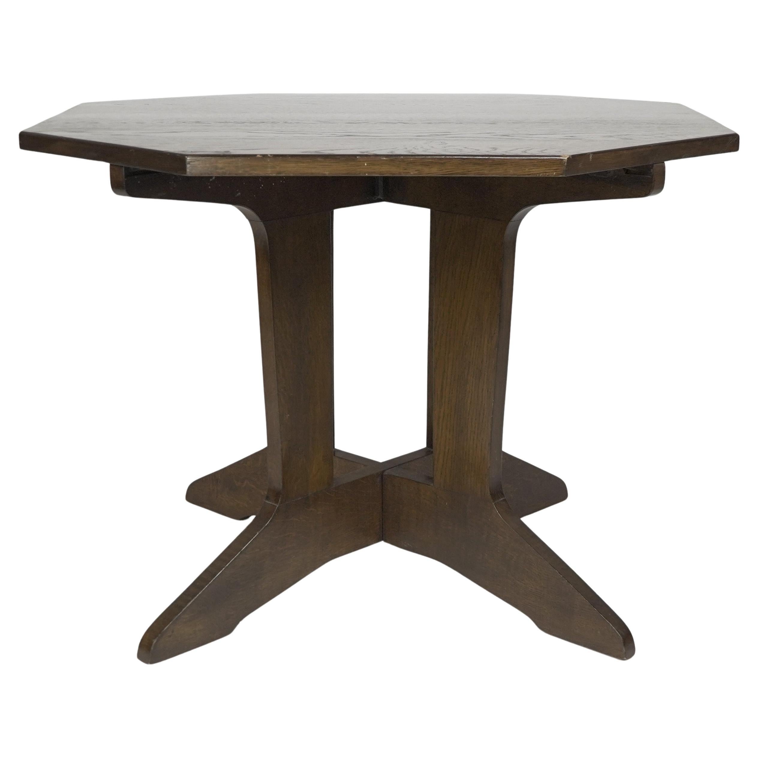 An Arts & Crafts good quality oak octagonal centre table with curved supports.