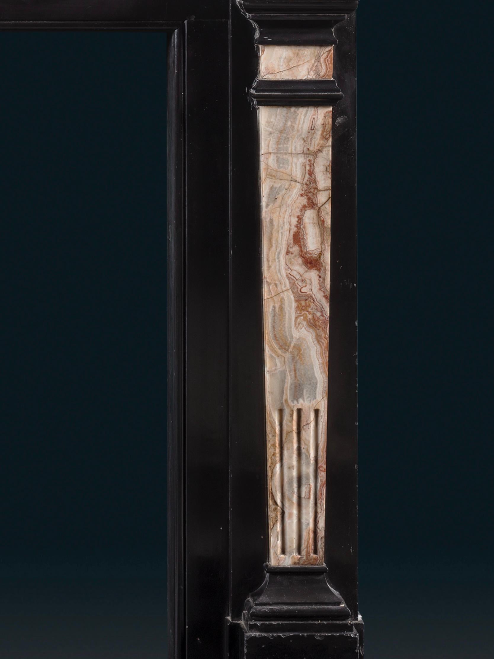 19th Century A Late Regency Chimneypiece Carved from Belgium Black Marble with Specimen Onyx For Sale