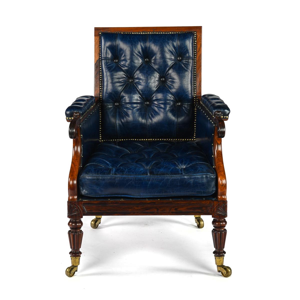 La forma ampliamente rectangular de esta silla está ornamentada con patas traseras cabriolé curvadas, patas delanteras talladas en forma de caña y antemuro y reposabrazos sinuosos. Fabricada con el mejor palisandro, las barandillas están paneladas y