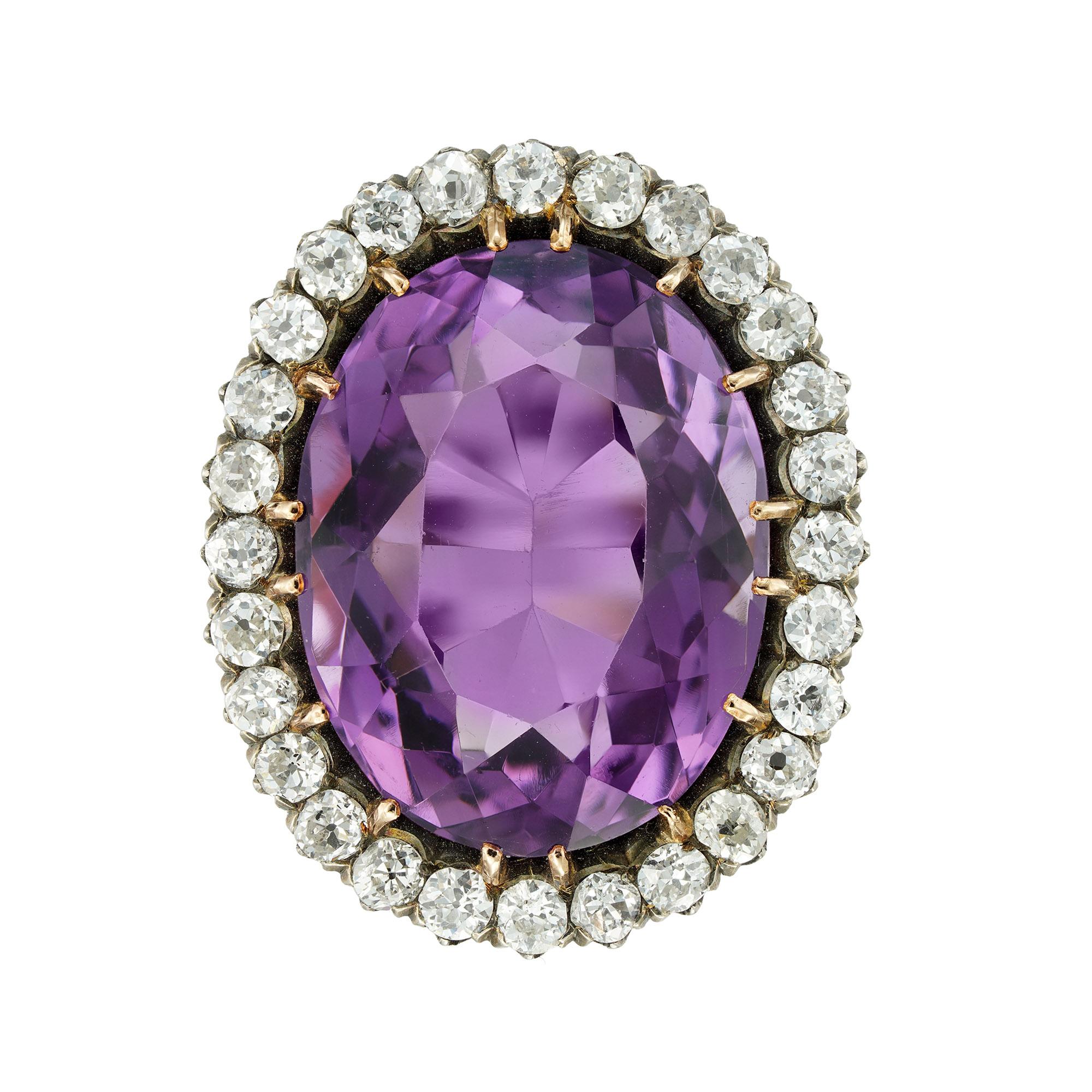 A late Victorian amethyst and diamond cluster ring, the oval faceted amethyst weighing 25.5 carats surrounded by twenty-eight old European-cut diamonds estimated to weigh 2 carats in total, all claw-set in silver and yellow gold, to gold penwork