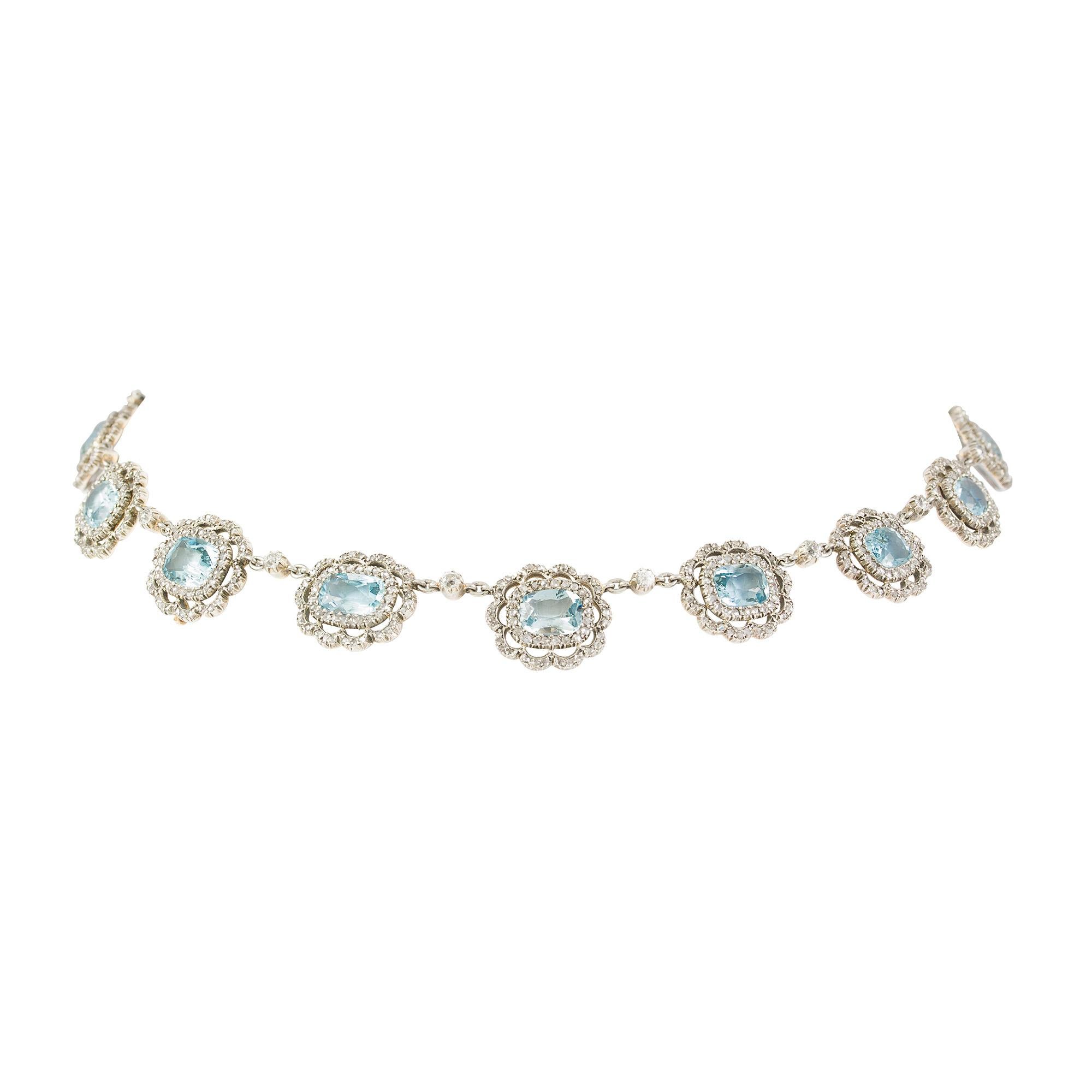 A late Victorian aquamarine and diamond cluster necklace, the sixteen cushion shape aquamarines, estimated to weigh a total of 26 carats, surrounded by a double cluster of rose-cut diamonds with old brilliant-cut diamonds inbetween, all to a cut