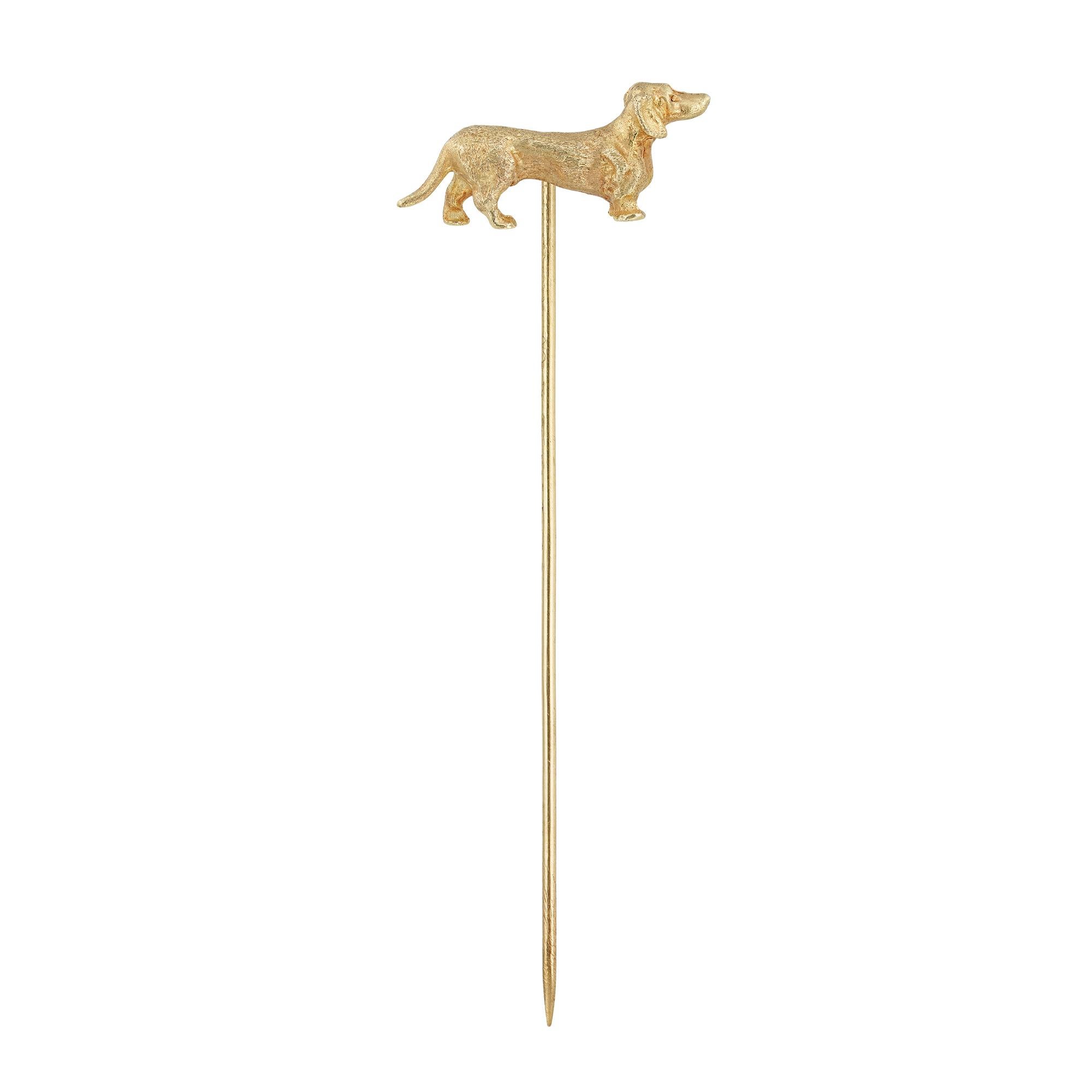 A late Victorian dachshund stick-pin, the realistically carved dog made in yellow gold, with gold pin fitting, circa 1900, unmarked, tested as 14ct gold with 18ct gold pin, measuring 2.1 x 1cm, the pin measuring 6.5cm long, gross weight