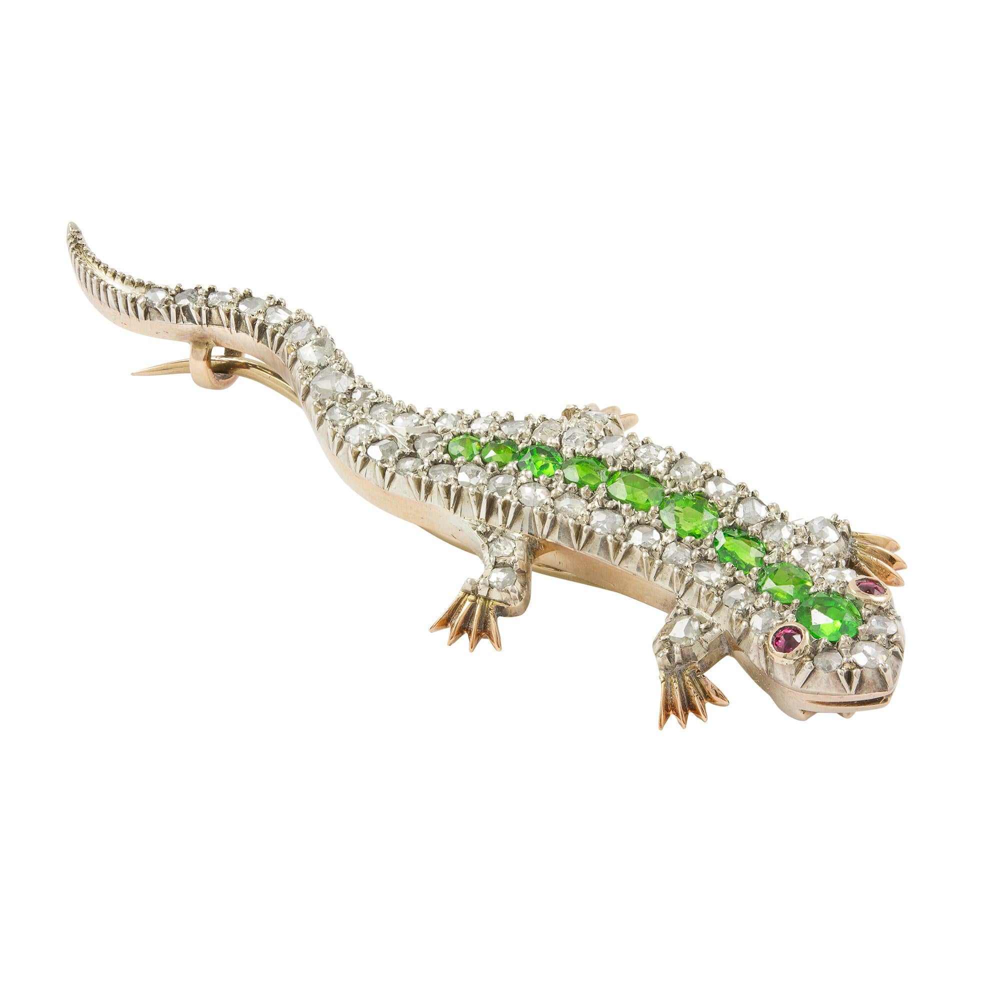 A late Victorian demantoid garnet and diamond brooch, the naturalistically modelled lizard encrusted with rose-cut diamonds and embellished to the spine with a row of nine graduated oval mixed-cut demantoid garnets, all silver set to a yellow gold