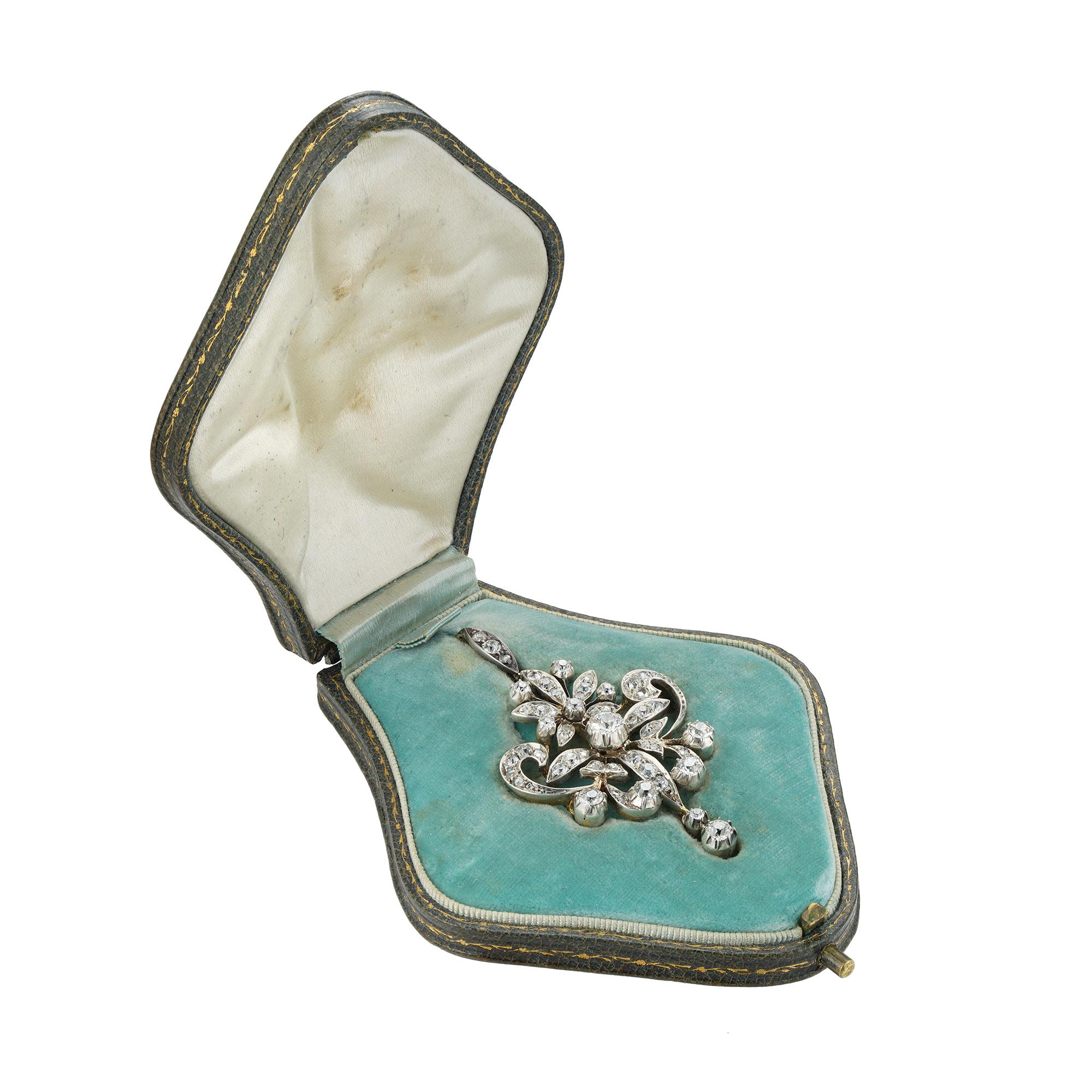 Una spilla/pendente tardo-vittoriana con diamanti graduati di taglio vecchio europeo e rosa, con un motivo a volute e a fogliame traforato, che sospende una goccia di diamante incastonata, con una cava di diamanti staccabile; i diamanti hanno un