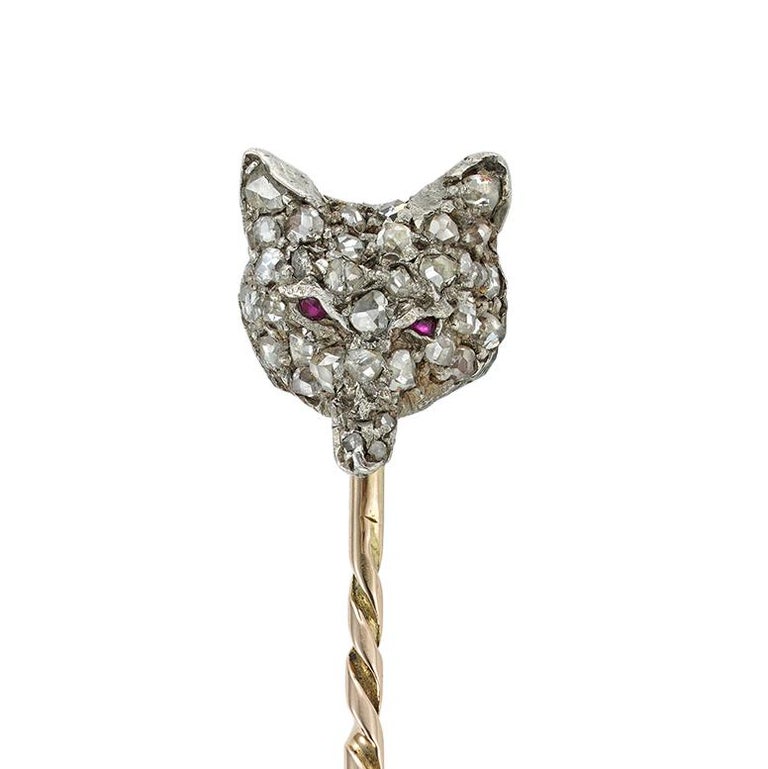 A late Victorian diamond-set fox stick-pin, the realistically carved fox head set with rose-cut diamonds and cabochon-cut ruby-set eyes, all set in silver to yellow gold back and pin, circa 1890, the jewelled part measuring 1.4 x 1.1cm, gross weight