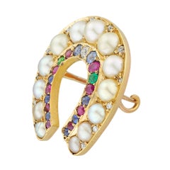 A late Victorian half-pearl and multi-gem horseshoe brooch