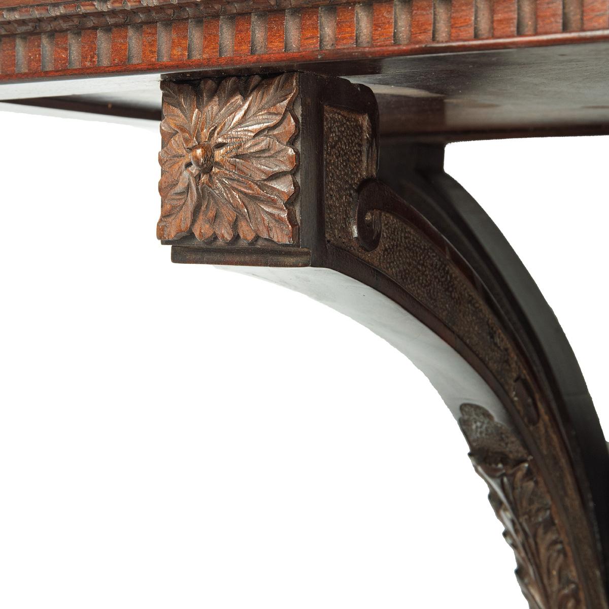Ménsula de pared de caoba de finales de la época victoriana para un reloj, de Edwards and Roberts; la repisa rectangular está colocada sobre tres brazos que convergen en un saliente central flanqueado por un panel de llave griega, finamente tallado