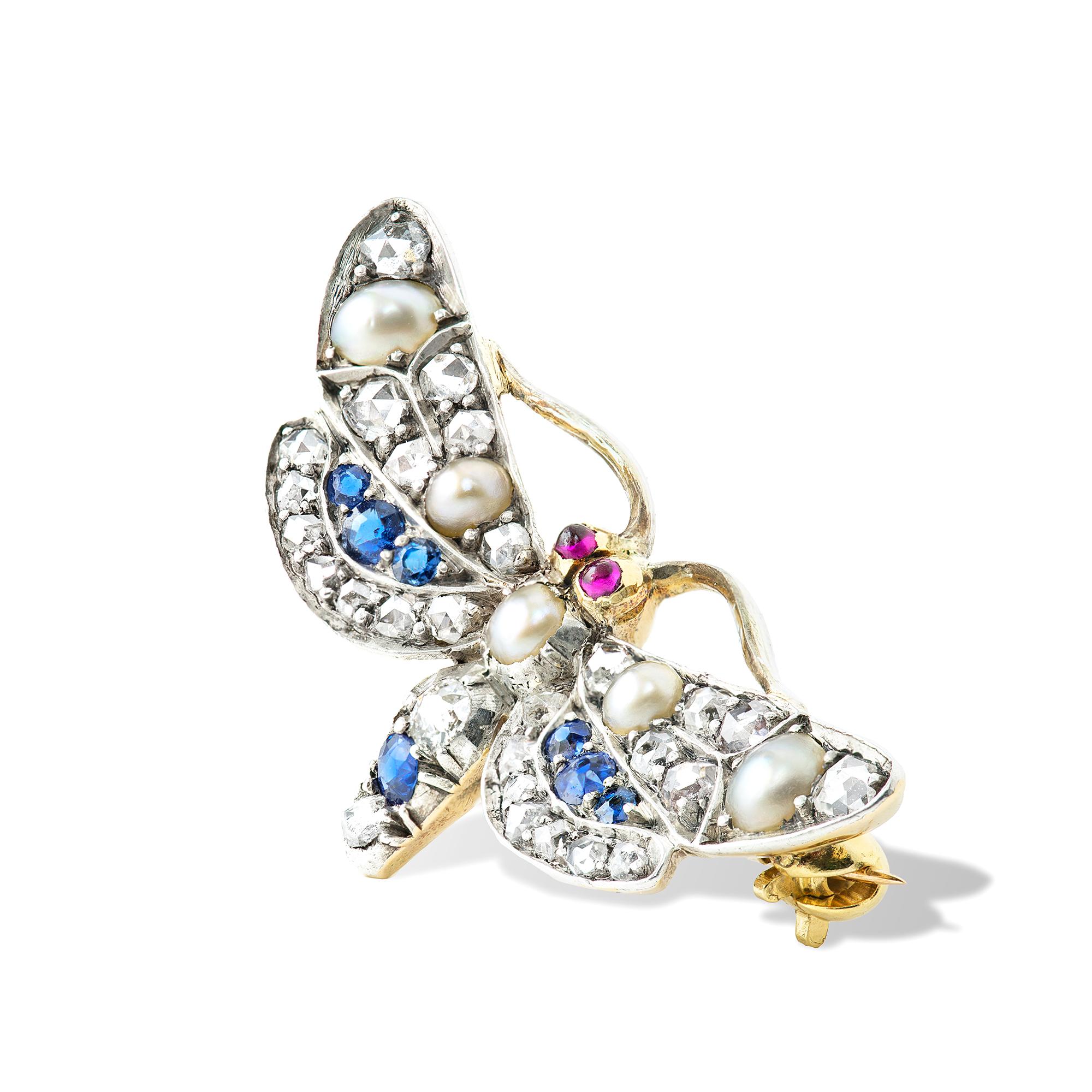 A late Victorian multi-gem butterfly brooch, set with half pearls, diamonds and sapphires with ruby-set eyes, set on silver to yellow gold back, circa 1900, measuring approximately 2.7x1.3cm, gross weight 3.3 grams.

This antique brooch is in good