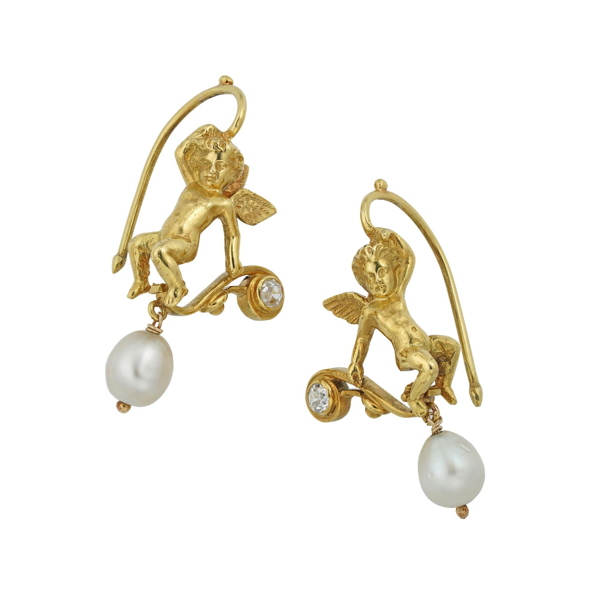 A late Victorian pair of natural pearl and diamond earrings, each earring with Eros, on the one hand holding a bow, the bow set with an old-cut diamond on the one finial and suspending a natural pearl drop on the other, on the other hand is holding