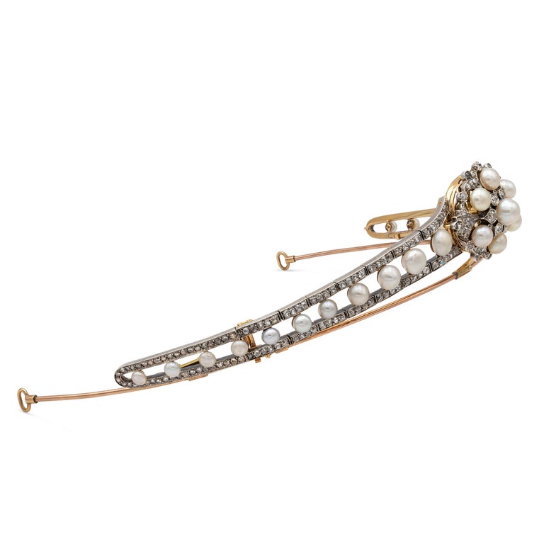 A late Victorian pearl and diamond tiara, to the centre a cluster in the form of a flowerhead, set with seven pearls and forty-two old European and rose-cut diamonds, to two graduated openwork slides each slide set with eleven pearls graduating in