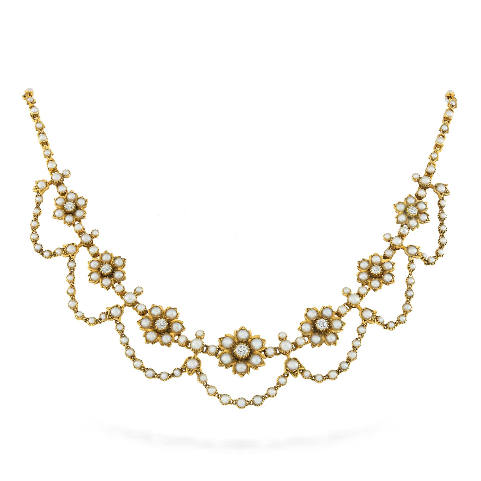 A late Victorian pearl, diamond and gold necklace, consists of seven graduated from the centre flower heads, each with an old cut diamond surrounded by six pearl-set petals, the flowerheads between eight pearl set bars with lily-of-the-valley