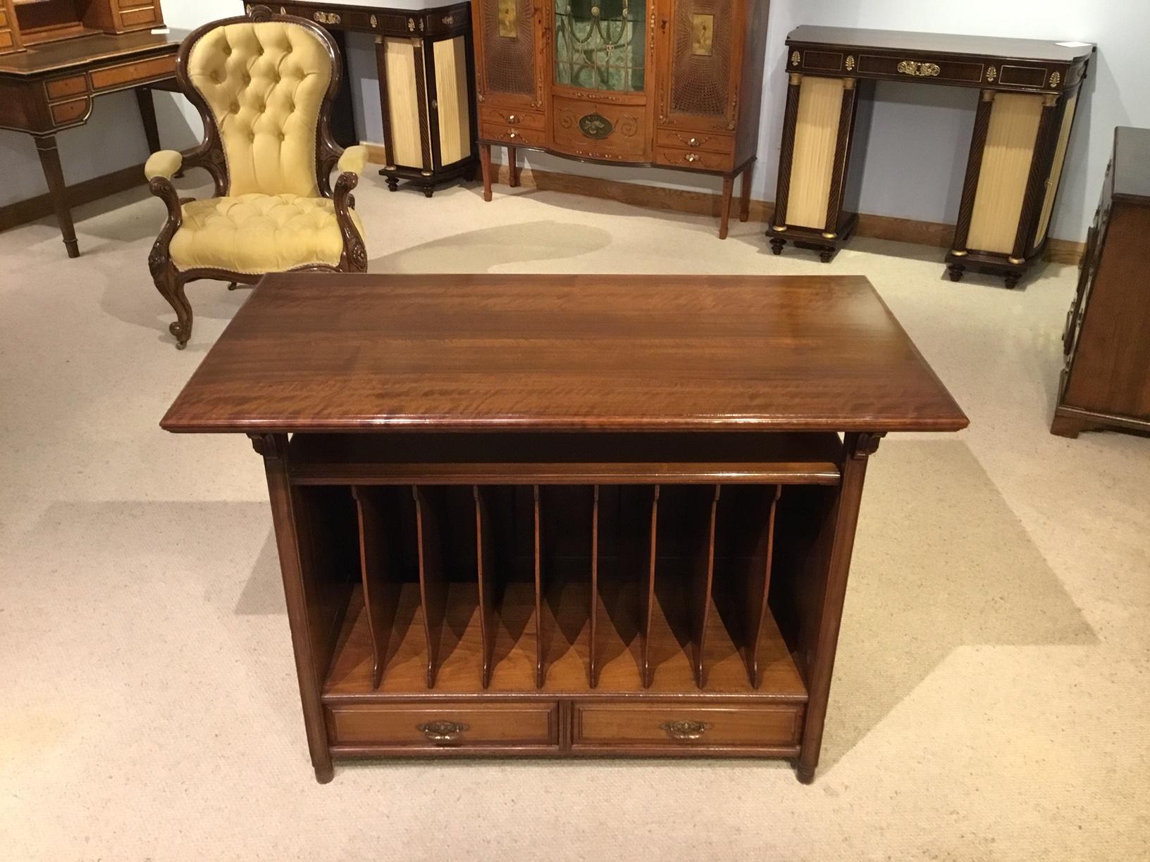 A late Victorian period aesthetic walnut TV/magazine stand. Having a rectangular solid walnut top supported by angular brackets above an open shelf and an eight division cabinet. The two mahogany lined lower drawers with finely cast brass handles,