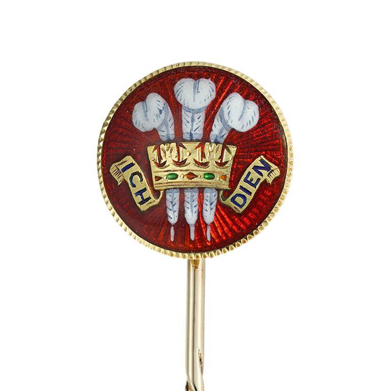 A late Victorian Prince of Wales stick-pin, the circular plaque with the Prince of Wales’s feathers and motto ‘ICH-DIEN’ (I serve), on red guilloche enamel background, made in yellow gold marked 18ct, with gold pin fitting,, circa 1900, the jewelled