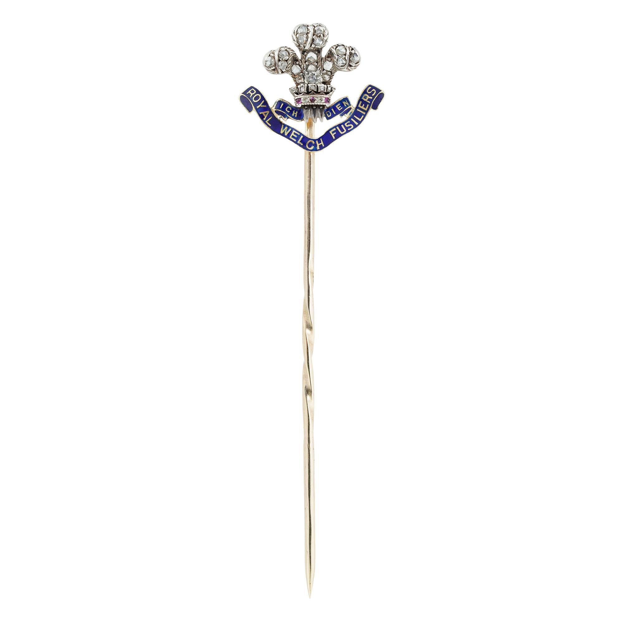 A late Victorian Royal Welch Fusiliers stick pin bearing the motto “Ich Dien” on a blue enamel banner with diamond set Prince of Wales feathers above, circa 1900, measuring 70mmx19mm, gross weight 2.5g.

This antique pin is in very good condition,