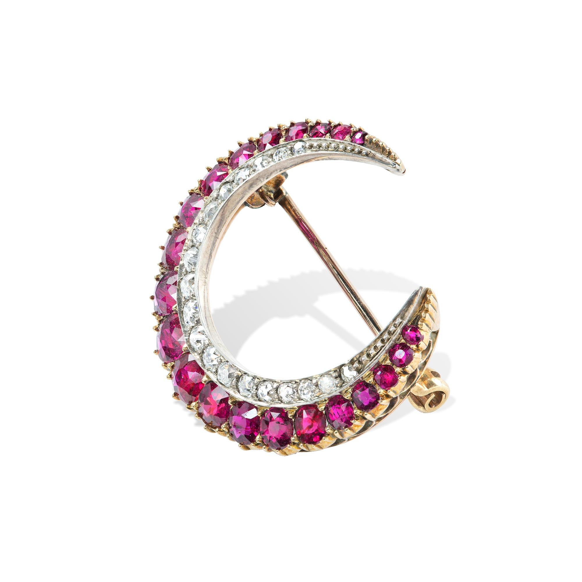 A late Victorian ruby and diamond crescent brooch, with one row of graduating cushion spape rubies estimated to weight 3.8 carats, and a  row of graduating old brilliant-cut diamonds estimated to weigh 0.65 carats, claw set in silver, all on gold