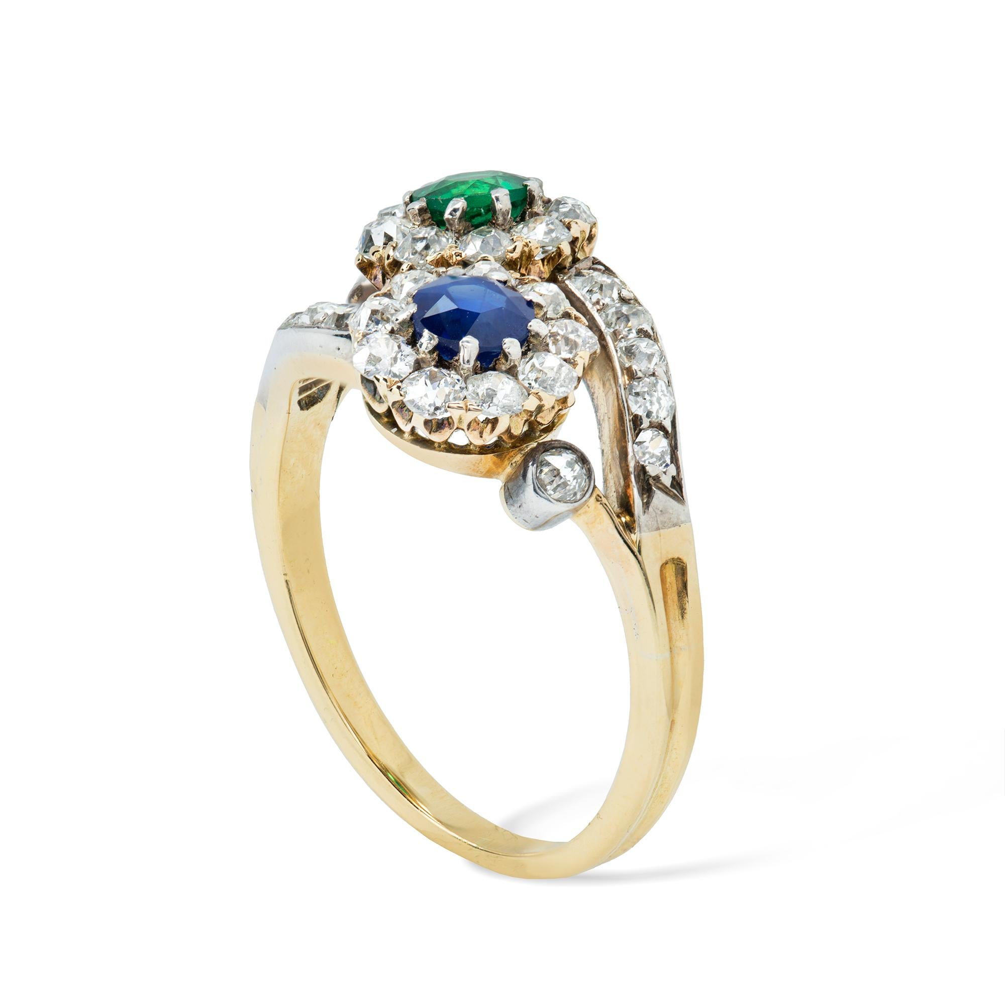 Anello con zaffiro, smeraldo e diamanti incrociati di epoca tardo-vittoriana, con al centro uno zaffiro del peso di 0,36 carati e uno smeraldo del peso di 0,22 carati, ciascuno all'interno di un gruppo di diamanti di taglio antico, su un gambo
