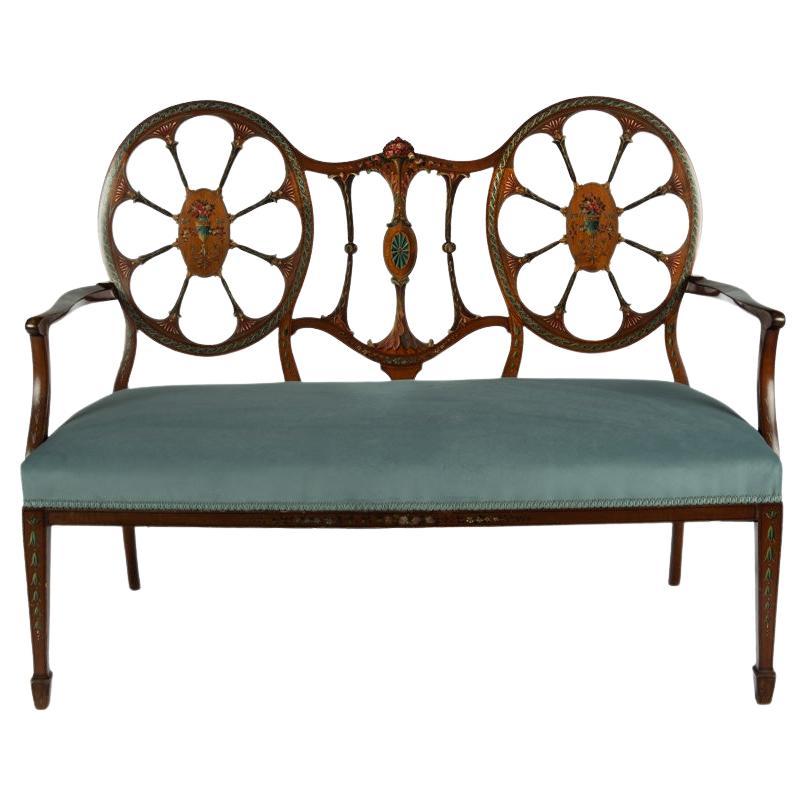 A late Victorian satinwood wheel back settee in the Chippendale style For Sale