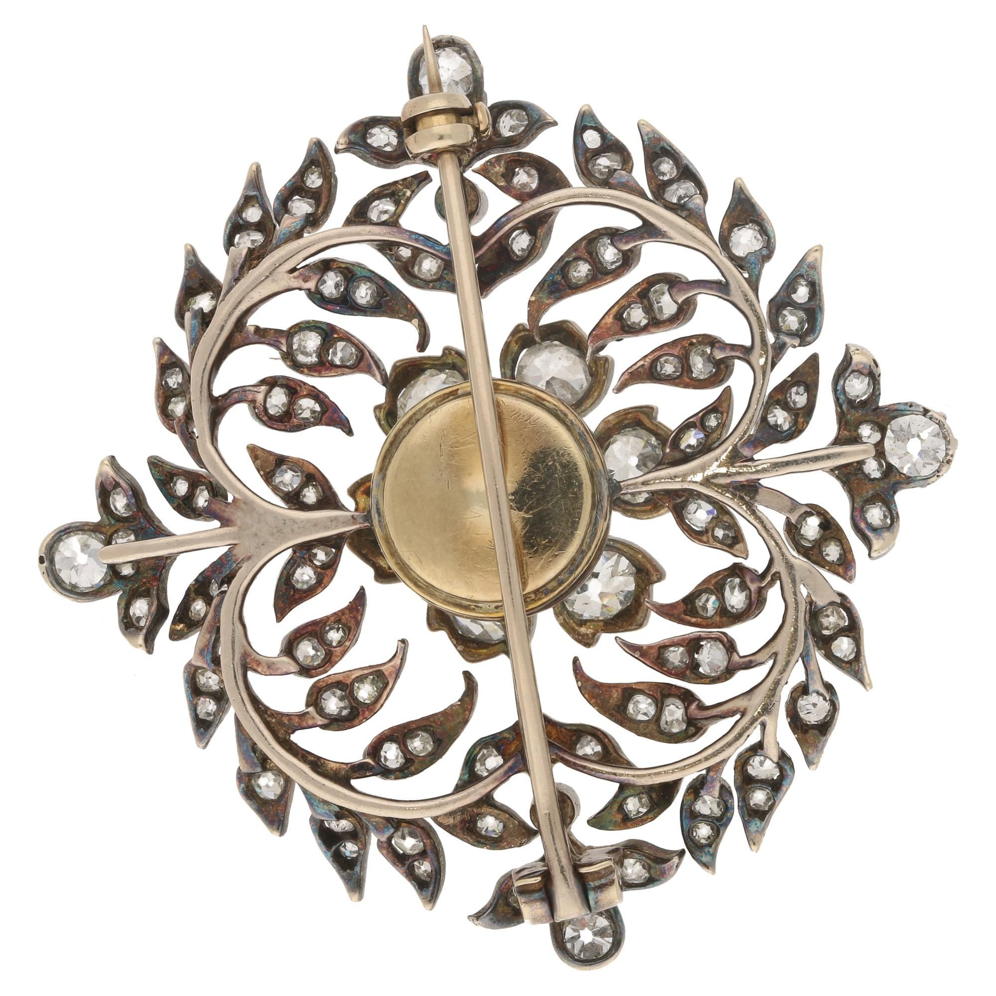 A stunning late Victorian diamond garland brooch set in silver-on-gold. The brooch is designed with a central old mine-cut diamond flower motif set 