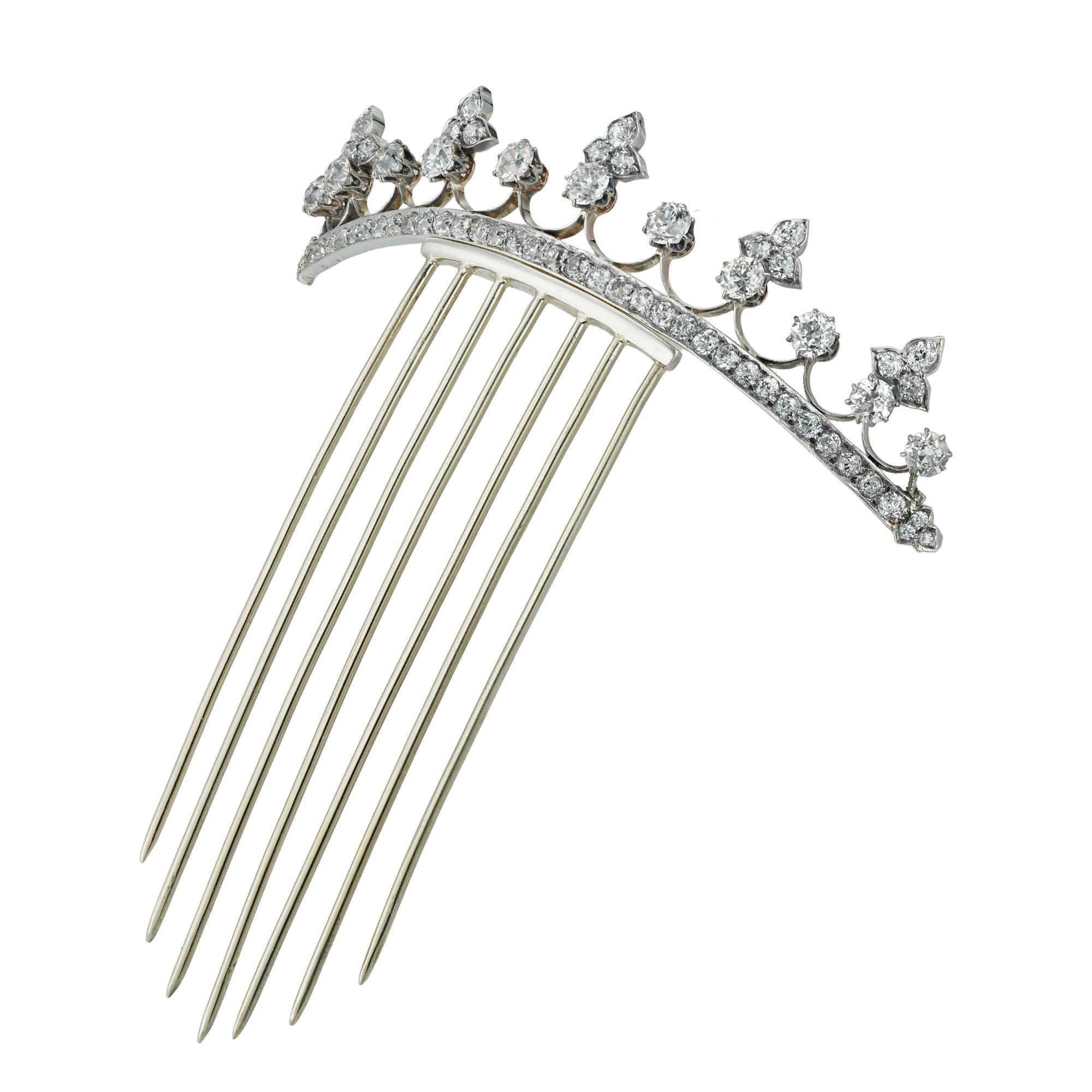A Late Victorian Small Diamond-set Tiara, consisting of eleven old mine-cut diamonds graduating from the centre, five of them flanked with trefoil diamond-set decorations , to openwork silver and gold scrolls, the base in the form of a line set with