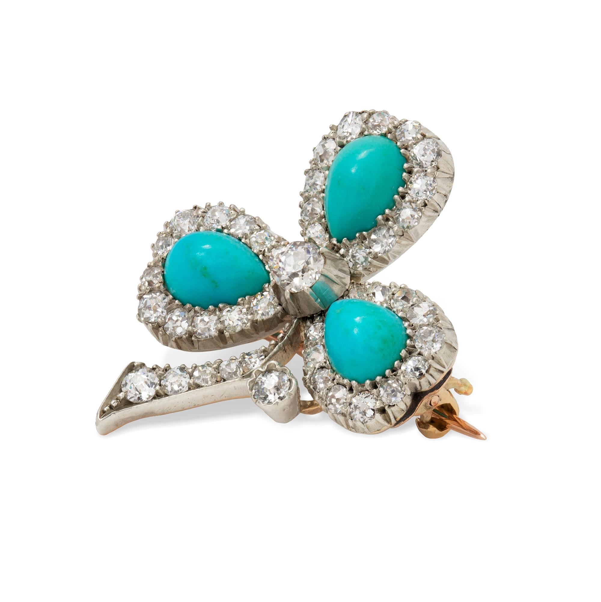 A late Victorian turquoise and diamond clover leaf brooch, the three leaves each set with a cabochon-cut pear-shaped turquoise to the centre of a cluster surround of old-cut diamonds, to a diamond-encrusted stalk, the diamonds estimated to weigh a