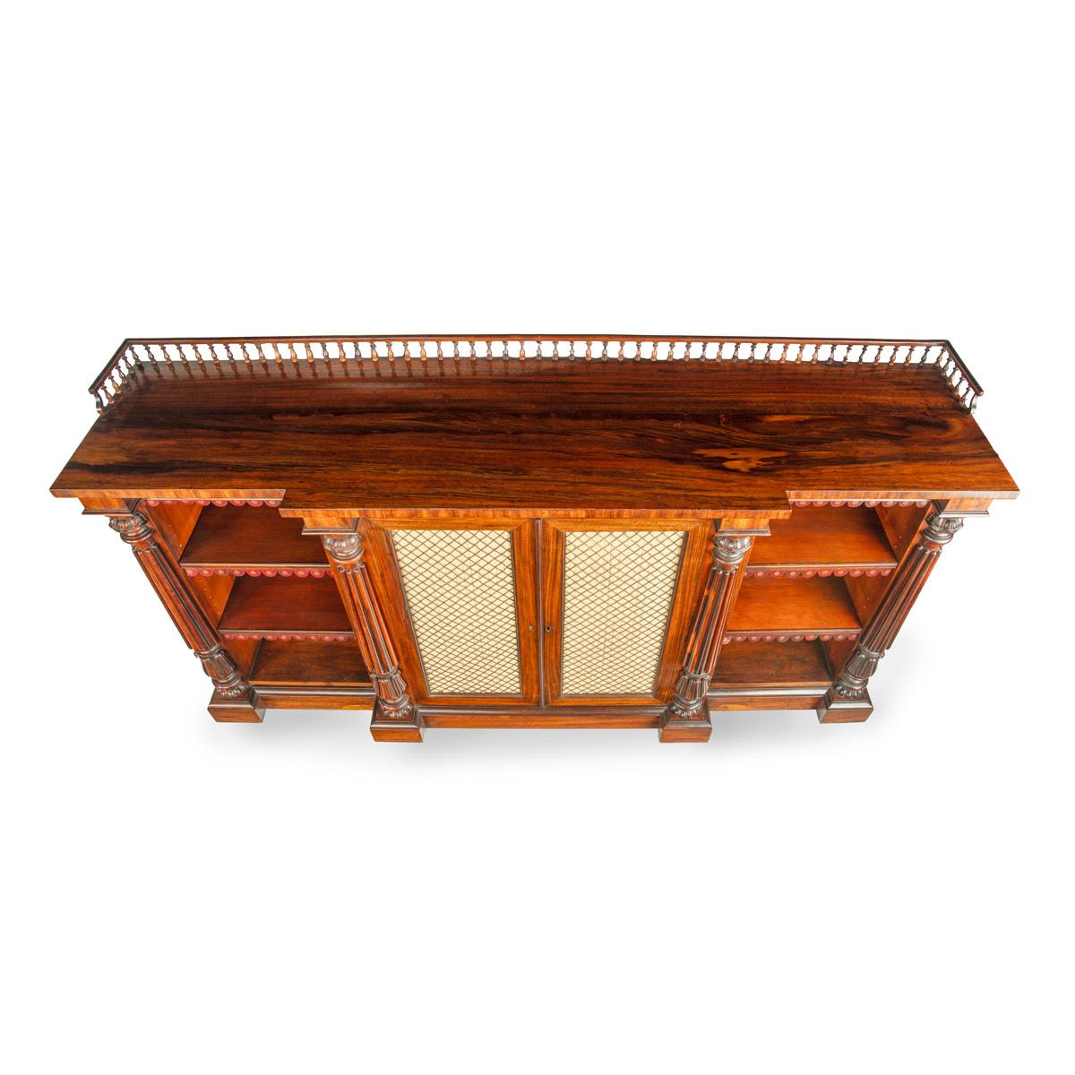 Libreria a giorno in legno di palissandro della fine di William Rosewood, di Gillows, con piano sagomato e galleria a balaustri torniti sopra quattro ante con pannelli in seta plissettata dietro griglie a traliccio di diamanti, che racchiudono due