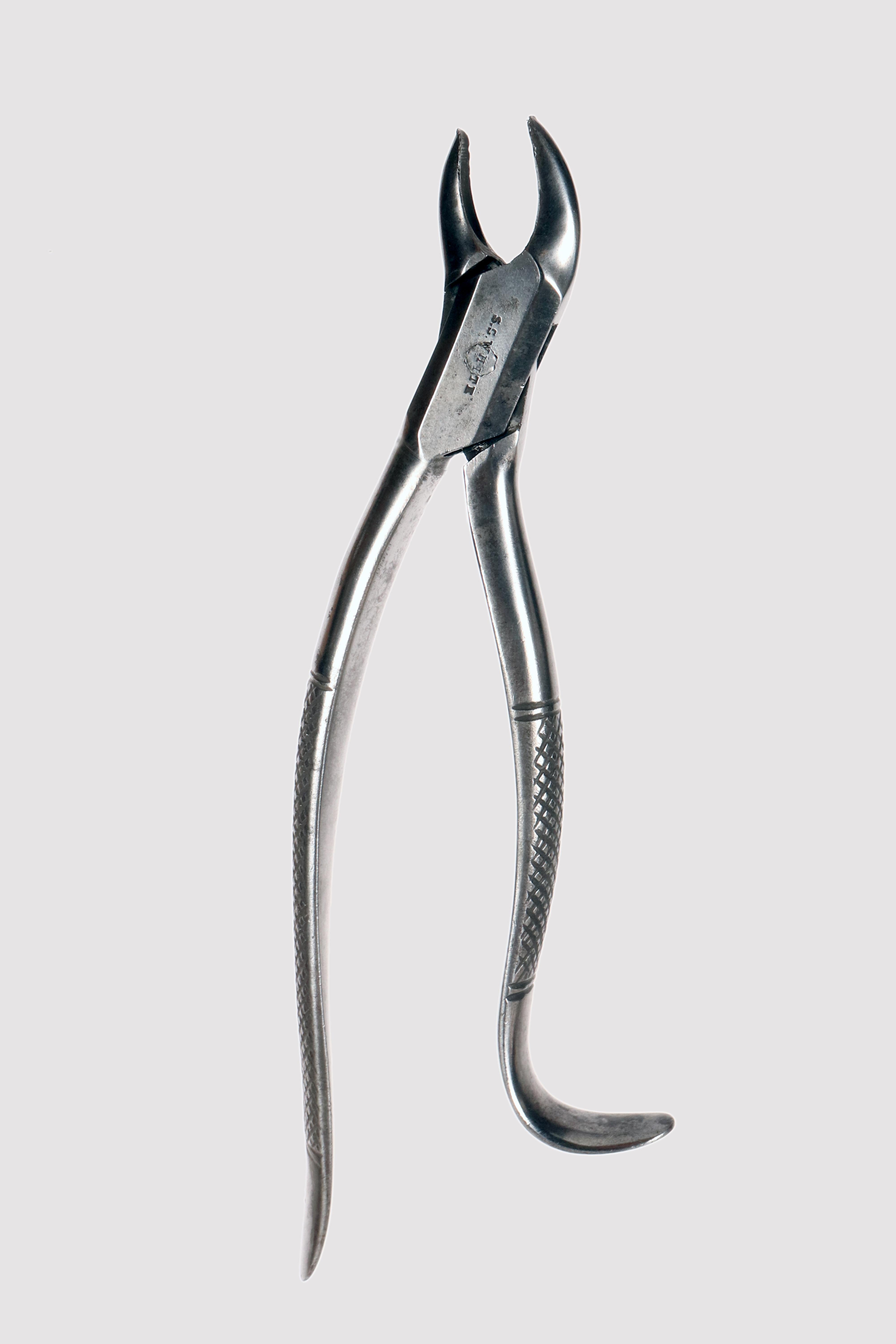 Instrument à usage dentaire. Extracteur dentaire de la fin du 19e siècle et du début du 20e siècle. Pince en fer utilisée pour l'extraction des dents. L'une des deux poignées est courbée pour permettre la préhension lors de l'extraction des dents.