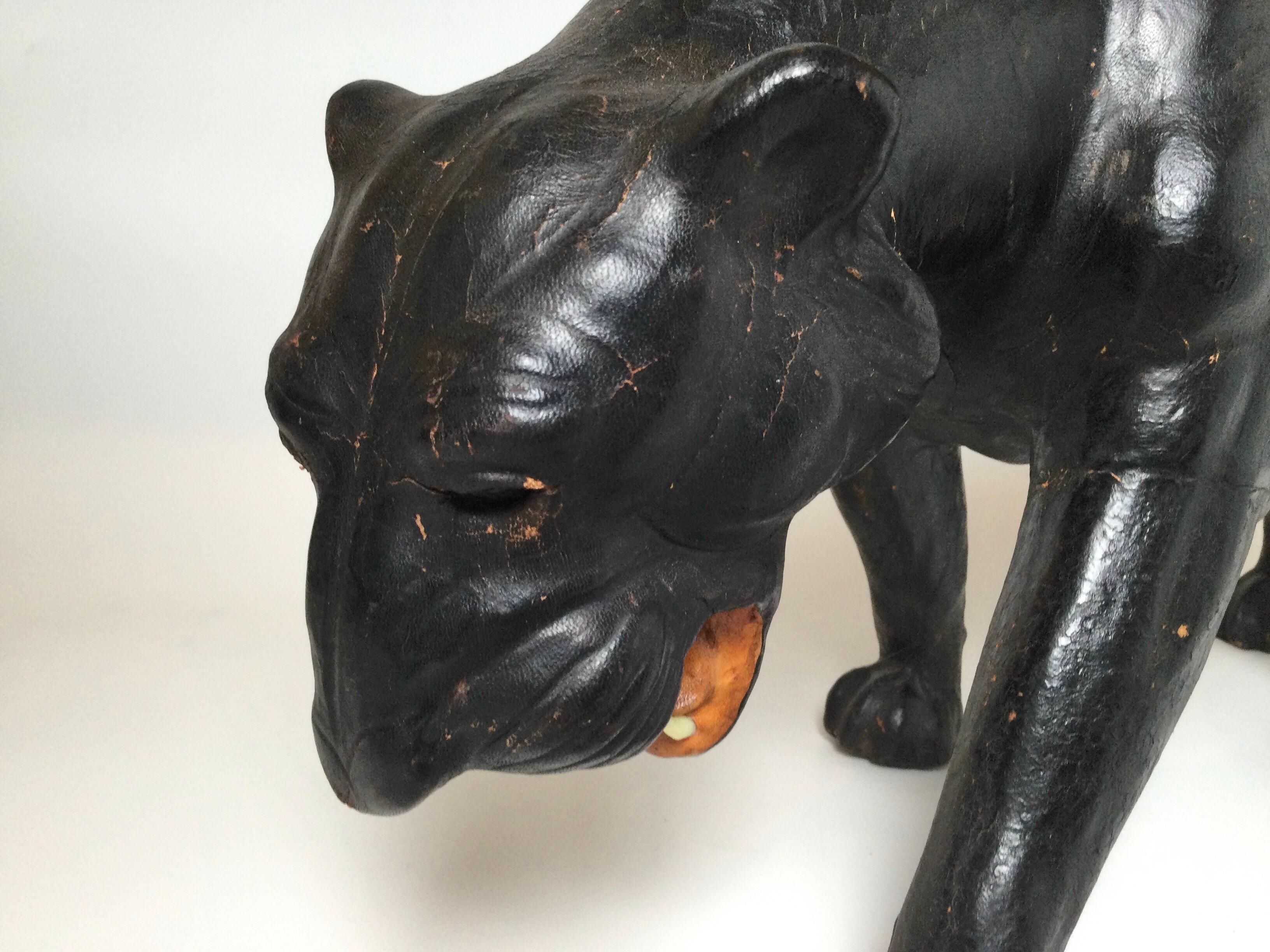 A black leather covered Paper Mache panther with glass eyes and teeth made of bone. Very chic style, 28 inches long.