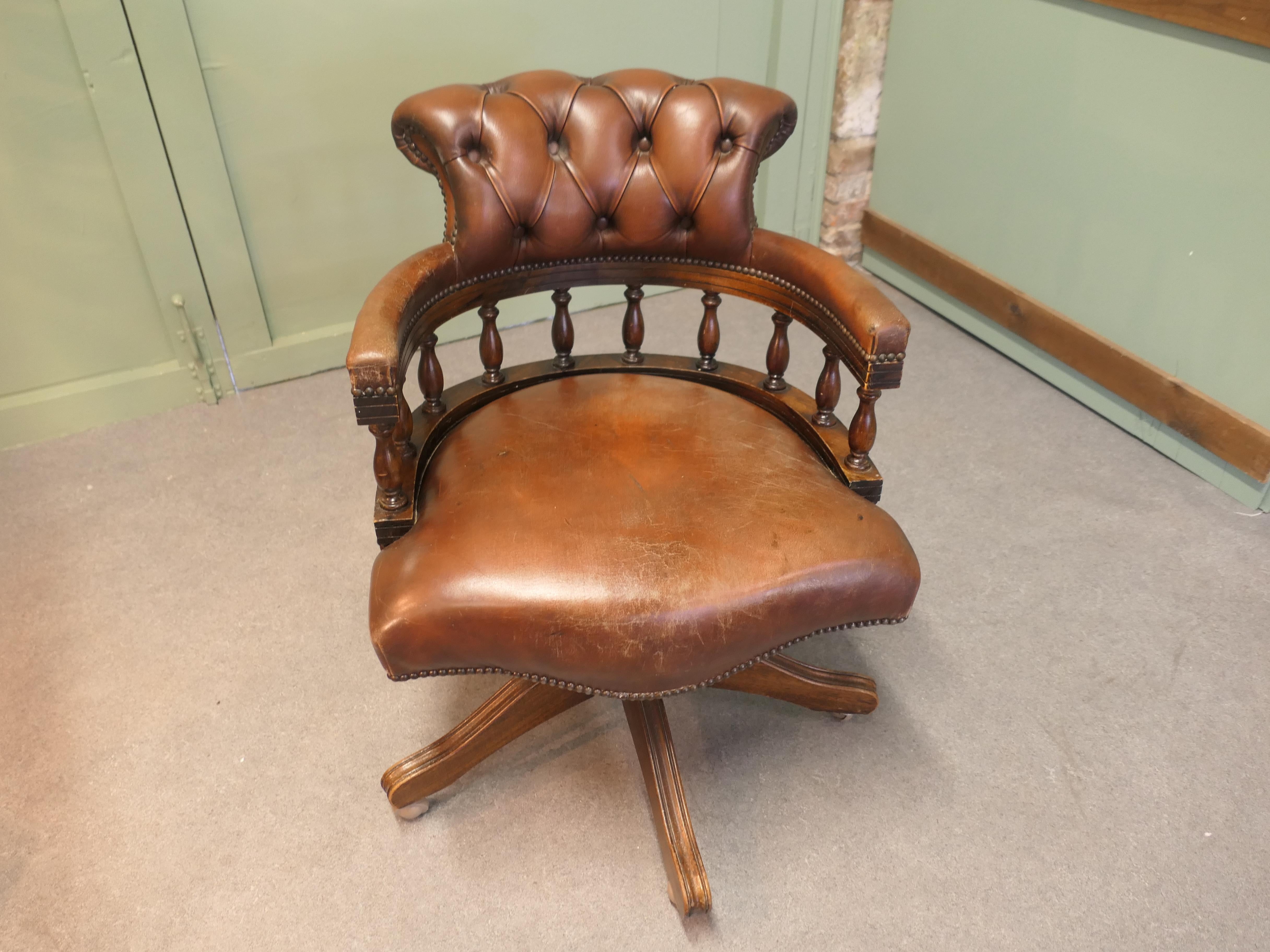 A Leather Hide Swivelling Desk Chair or Captains Chair  

The Chair has an attractive high curving upholstered back and top rail, the back rest is deeply buttoned for comfort, the chair spins, rises, tilts and swivels
The back of the chair is