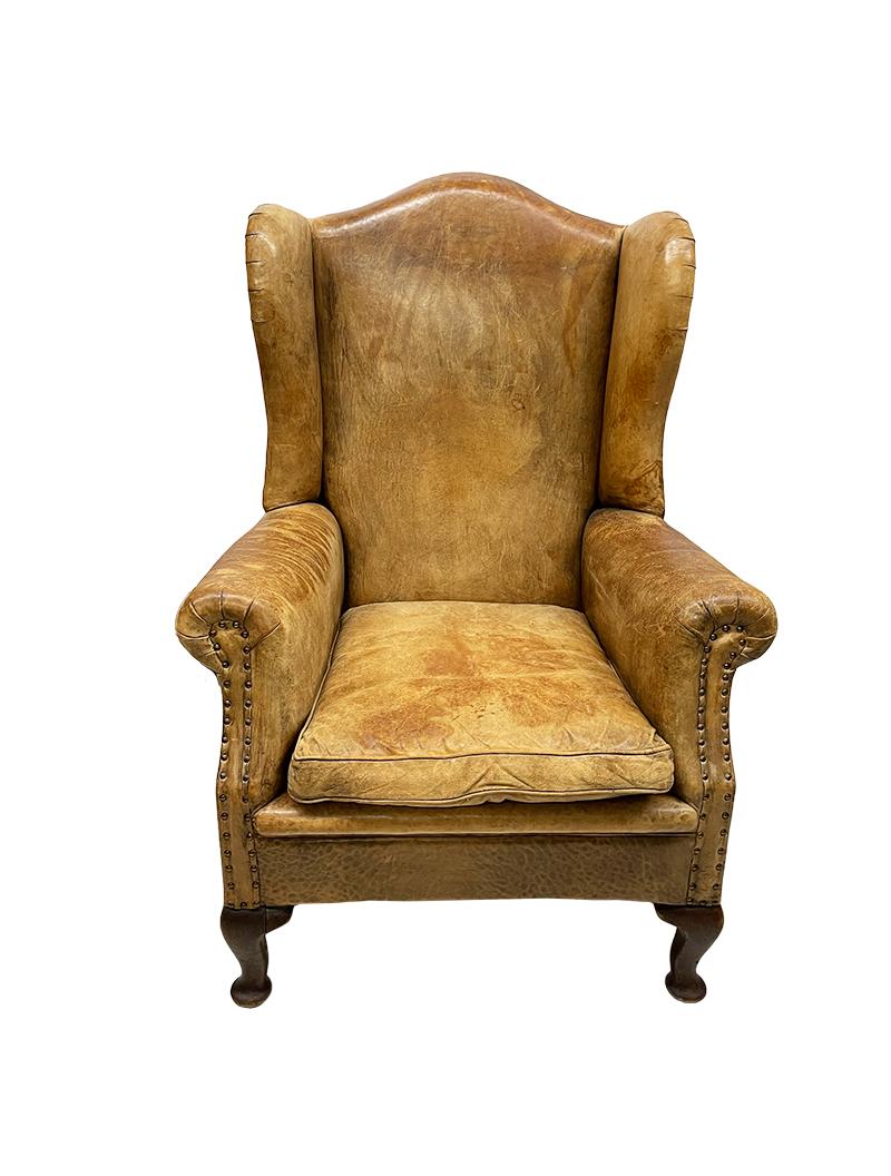 A leather wingback chair

A late 19th Century wingback chair in raw leather upholstery with dark oak Queen Anne front legs and straight oak rear legs. The bottom of the chair is webbed. The chair is fully upholstered with a decorative nail (1 nail
