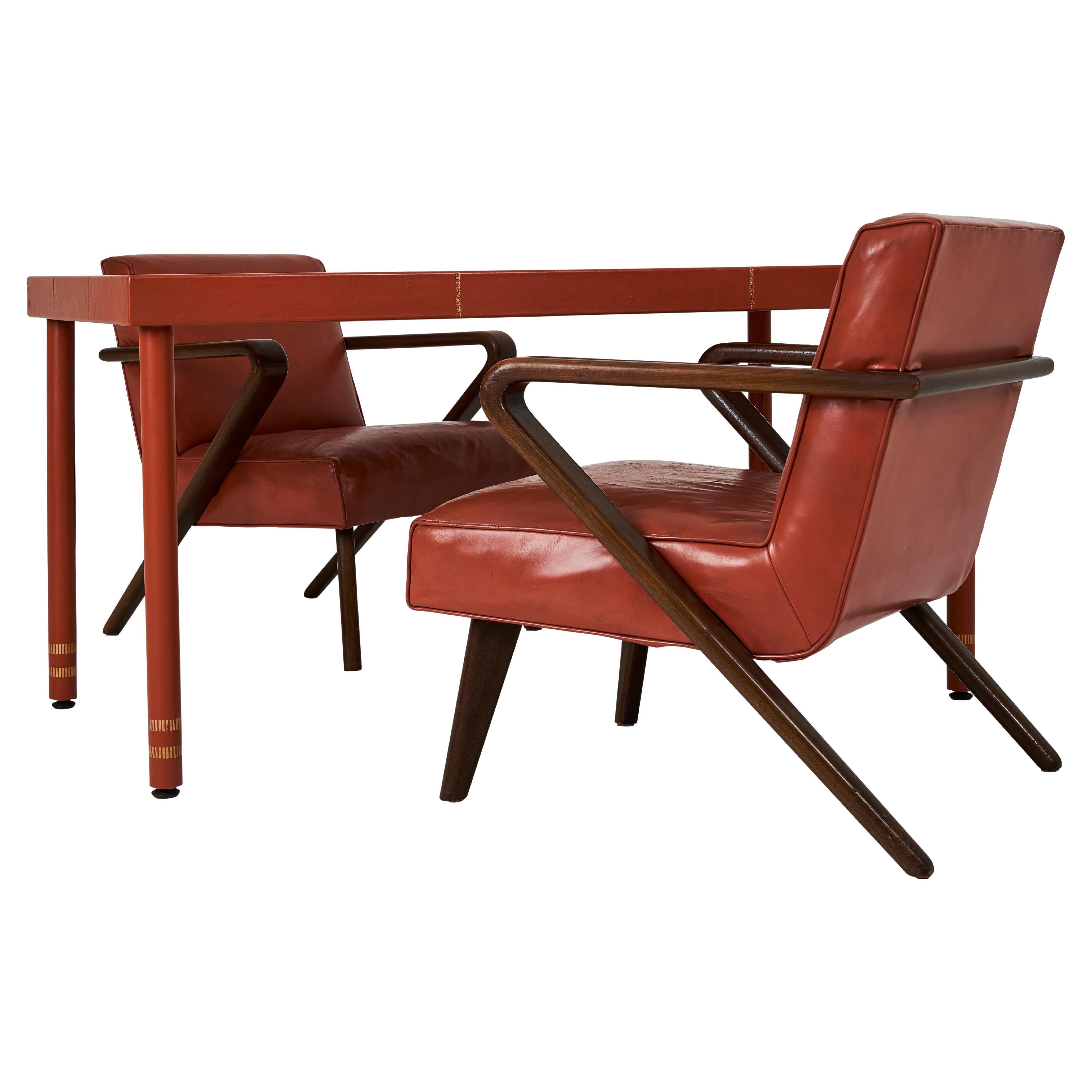 A Leather Wrapped Desk and Matching Arm Chairs designed by William Haines