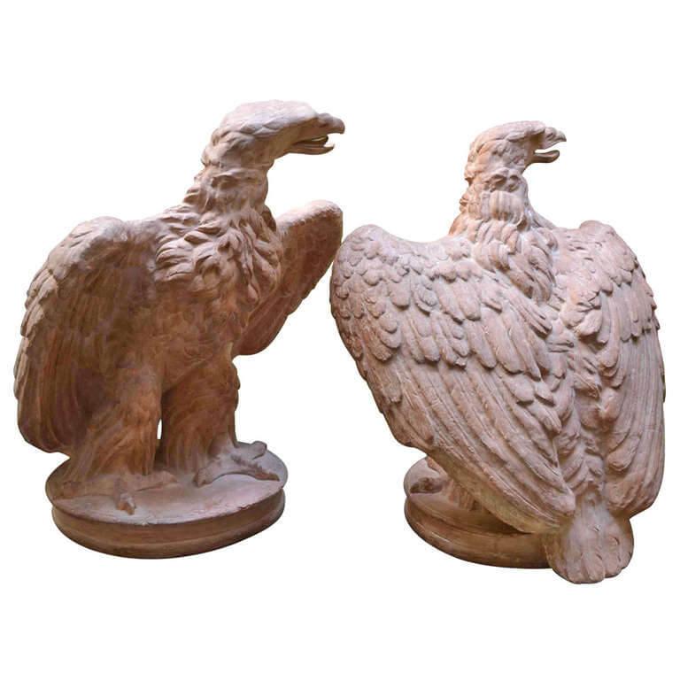 A life-Size pair of finely cast 19th century Italian terracotta eagles standing on an oval terracotta base, each facing the other with their wings partially upswept after a 1st Century AD Roman Original now displayed in Gosford Park England.

The