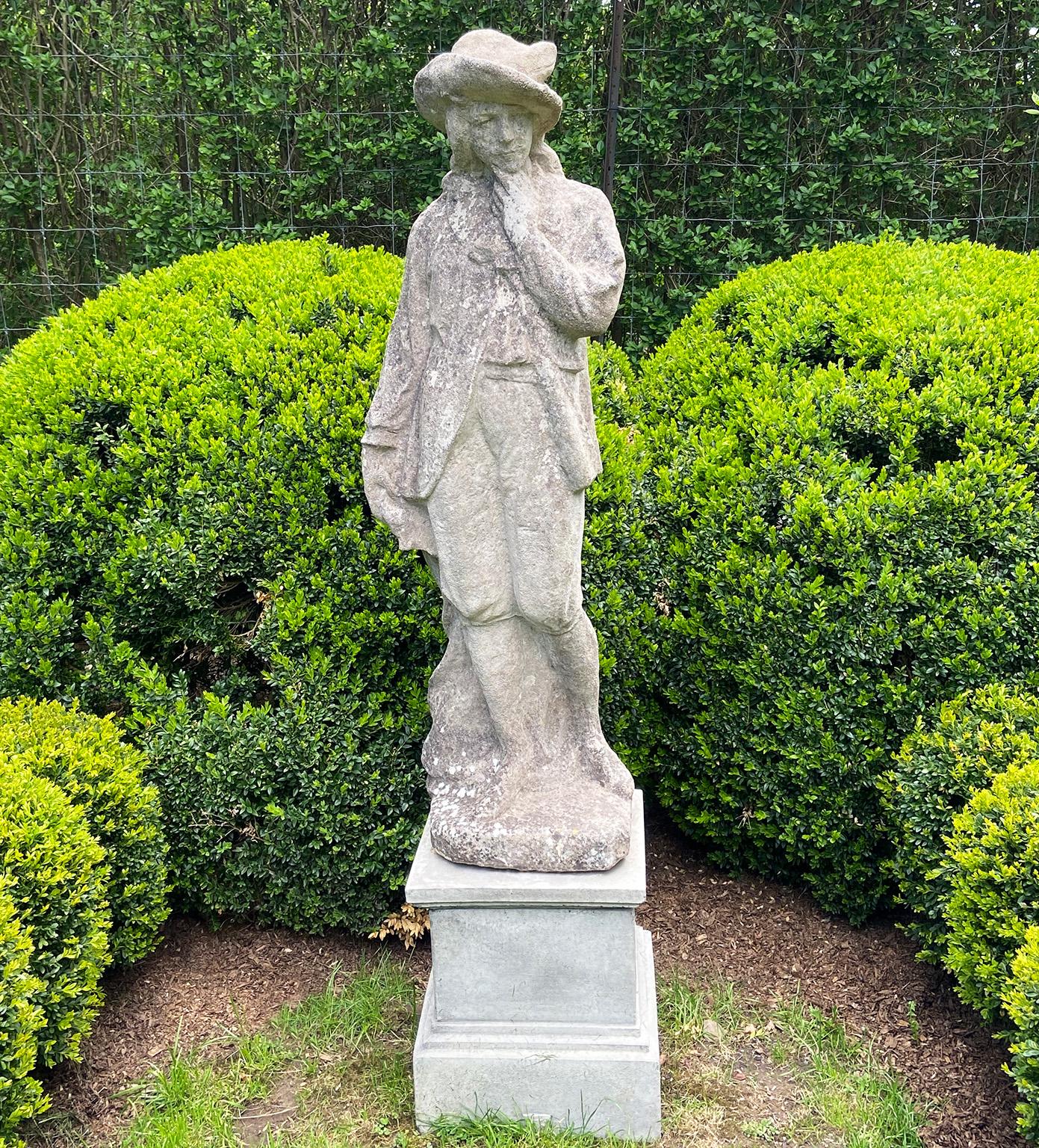 Figure en pierre de composition représentant un gentleman, debout, vêtu d'un long manteau et d'une culotte et coiffé d'un chapeau à larges bords, sa main gauche effleurant son menton, son visage pensif au regard tourné vers le bas, l'ensemble