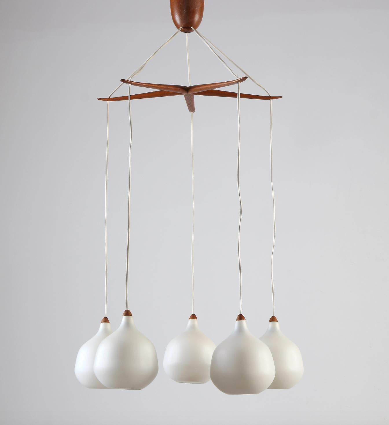 A Lighting pendant by UNO & ÖSTEN KRISTIANSSON.  Wood with shades in opaline glass. Produced by Luxus, Vittsjö. Circa 1950th.
Marked by manufacturer. Existing wires , rewiring available upon request.
Height 42.5″, diameter approx. 24″.