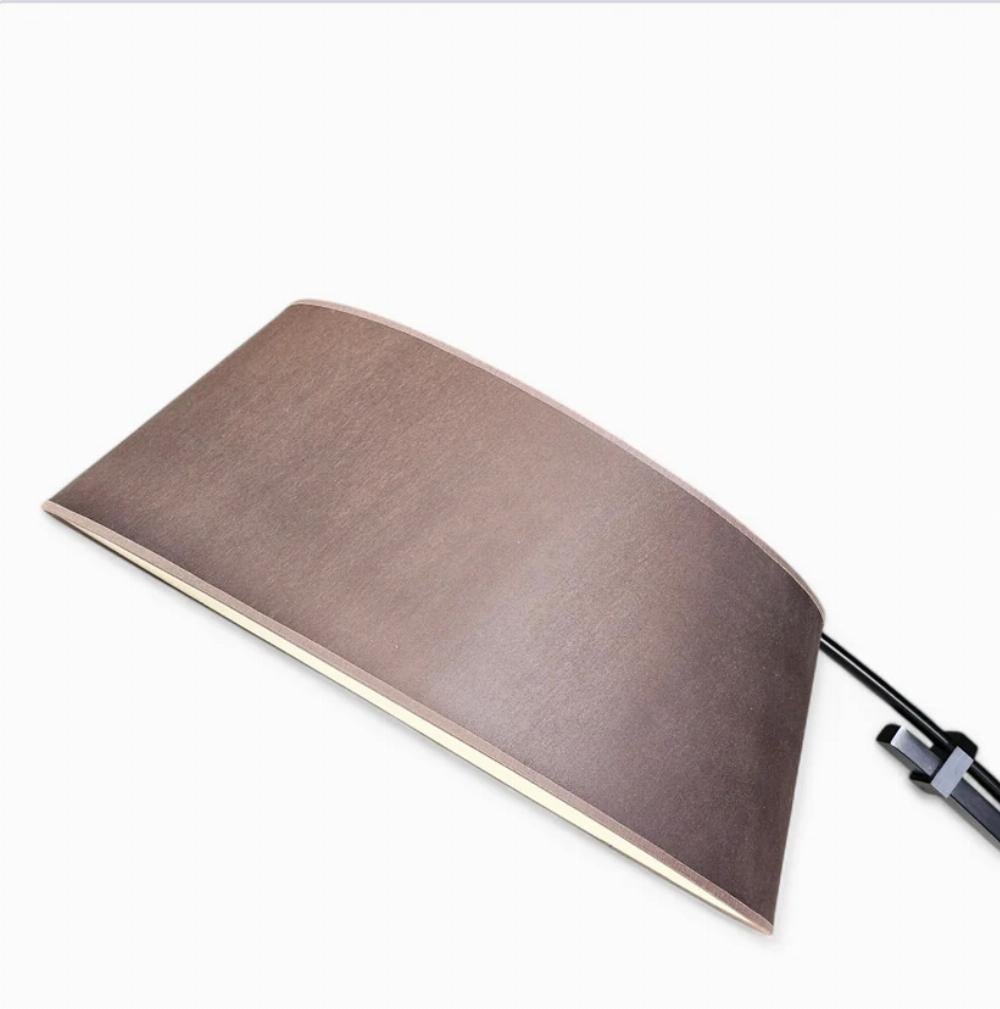 Elevate your space with the sleek and versatile Ouverture adjustable floor lamp, designed by Philippe Daney for Ligne Roset. Featuring a minimalist black steel base and stem paired with a warm brown shade, this timeless piece seamlessly blends