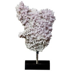 A lilac Amethyst Crystal Cluster mounted onto a mirrored steel base