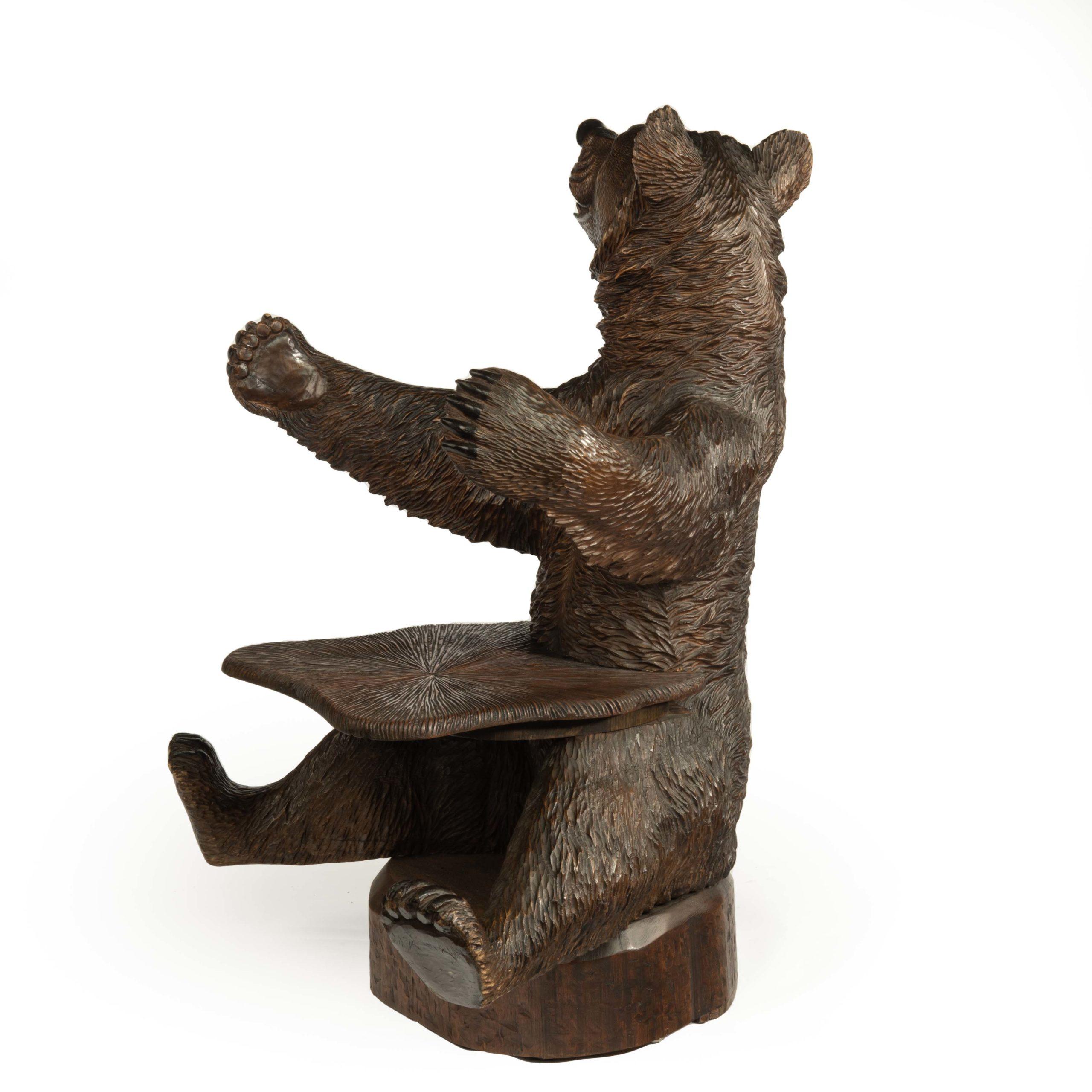 A linden wood ’Black Forest’ Bear armchair from Peter Trauffer, modelled as a seated bear with a radiating grooved seat in his lap, his paws outstretched in an embrace and his head turned to the right, the fur and sharp teeth realistically carved