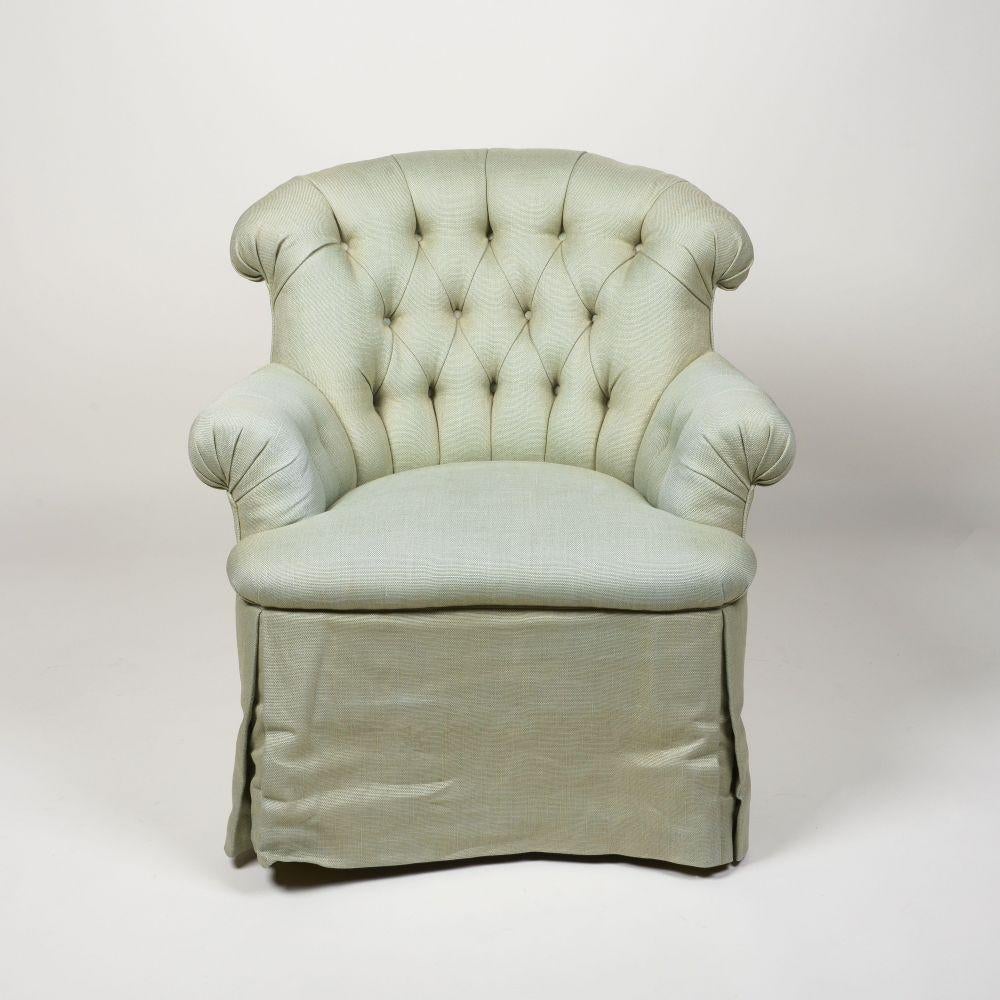 Covered in sage linen; with outward scrolling tufted rounded back and arms; the straight skirt concealing maple, square tapering feet.