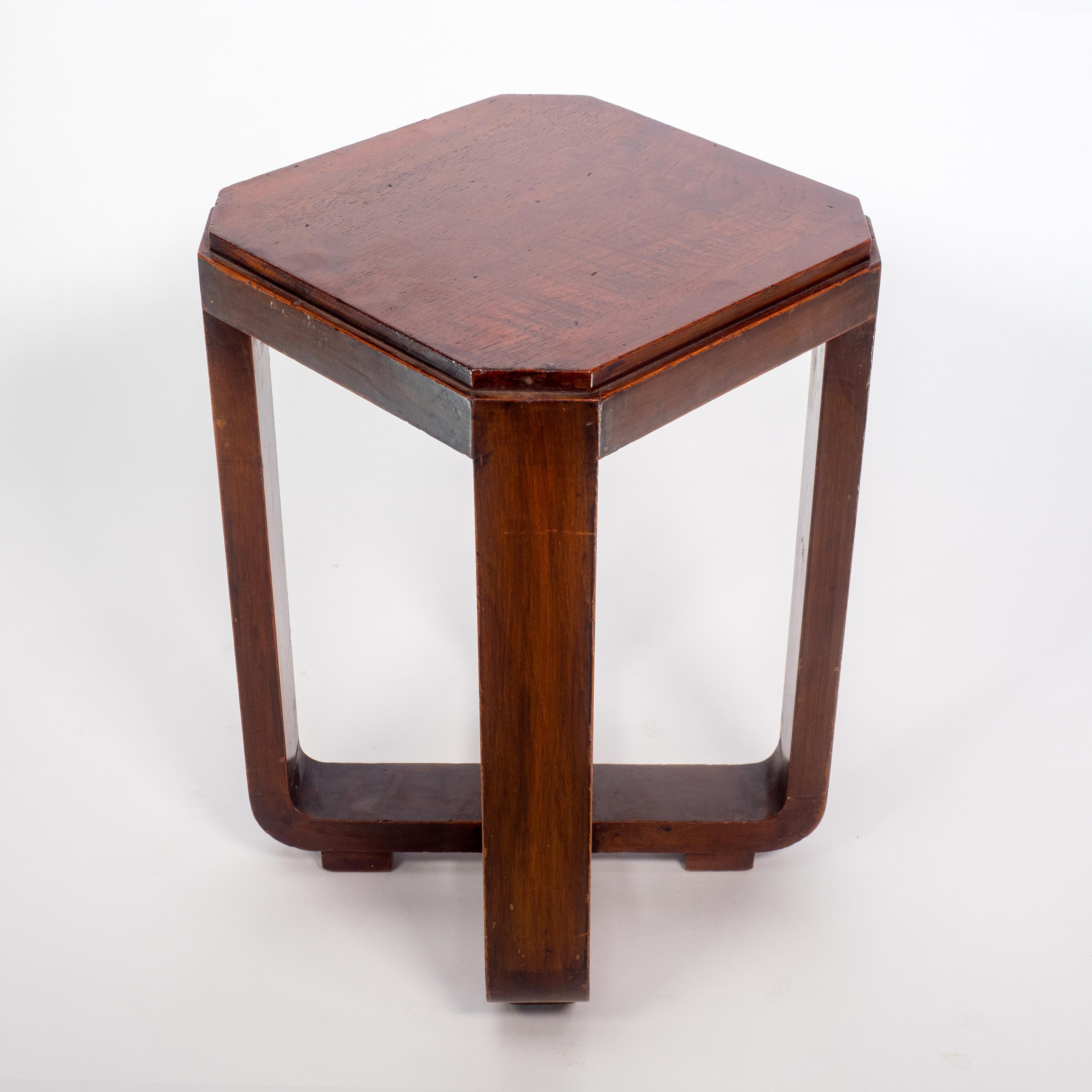 A little Art Deco Walnut side table, the legs follow down then through to a cross stretcher that laps in the center on little square block feet.