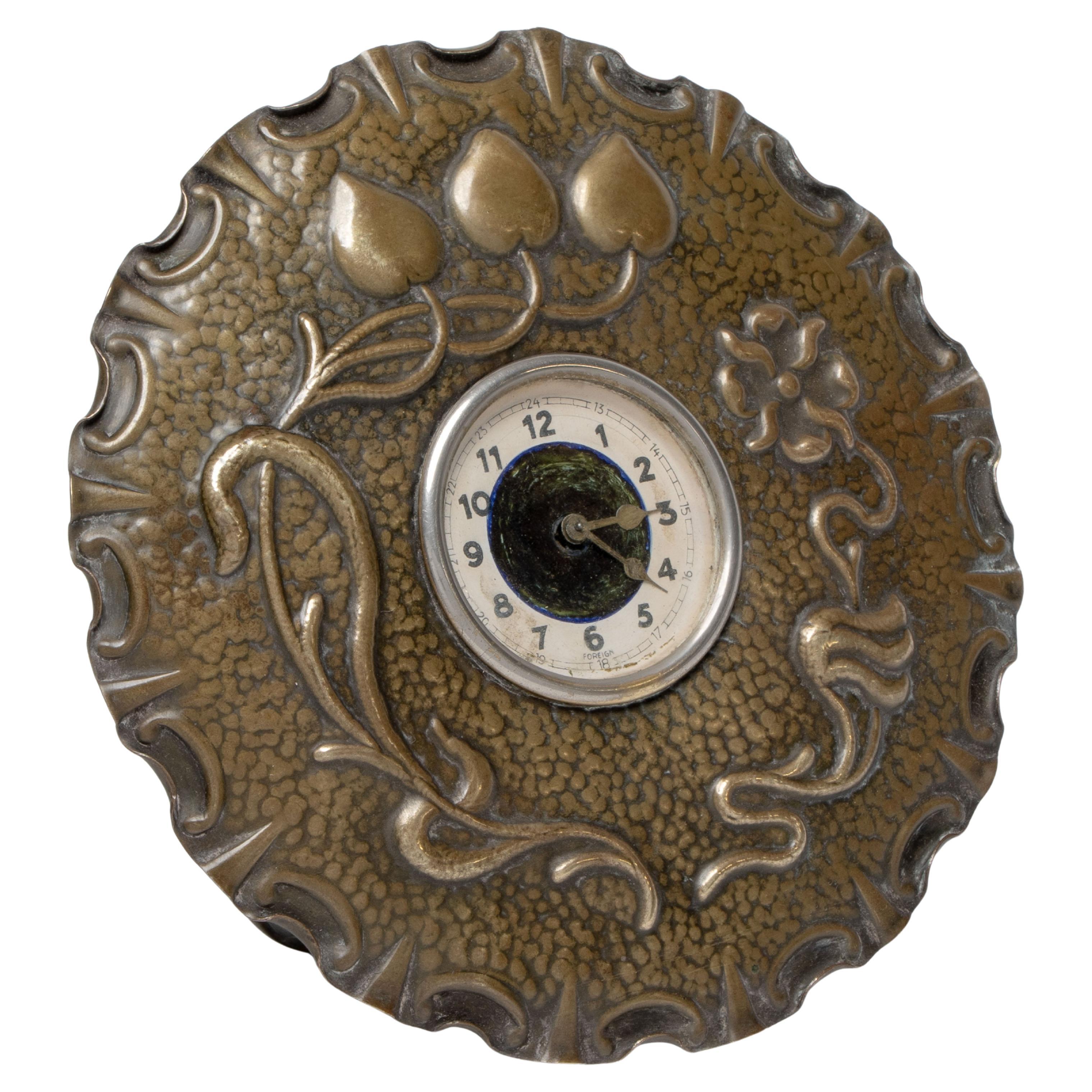 Une petite horloge de table Arts & Crafts en cuivre en forme de tête de fleur