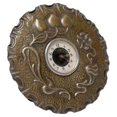 Une petite horloge de table Arts & Crafts en cuivre en forme de tête de fleur