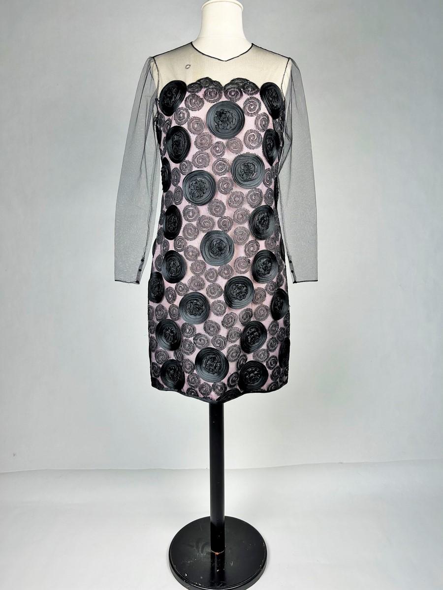 Circa 1968
France
Little evening dress in black tulle embroidered with spiral circles, unidentified haute couture, but Possibly Dior-Bohan, dating from the late 1960s. Short dress with straight cut and large halter neckline trimmed with black silk