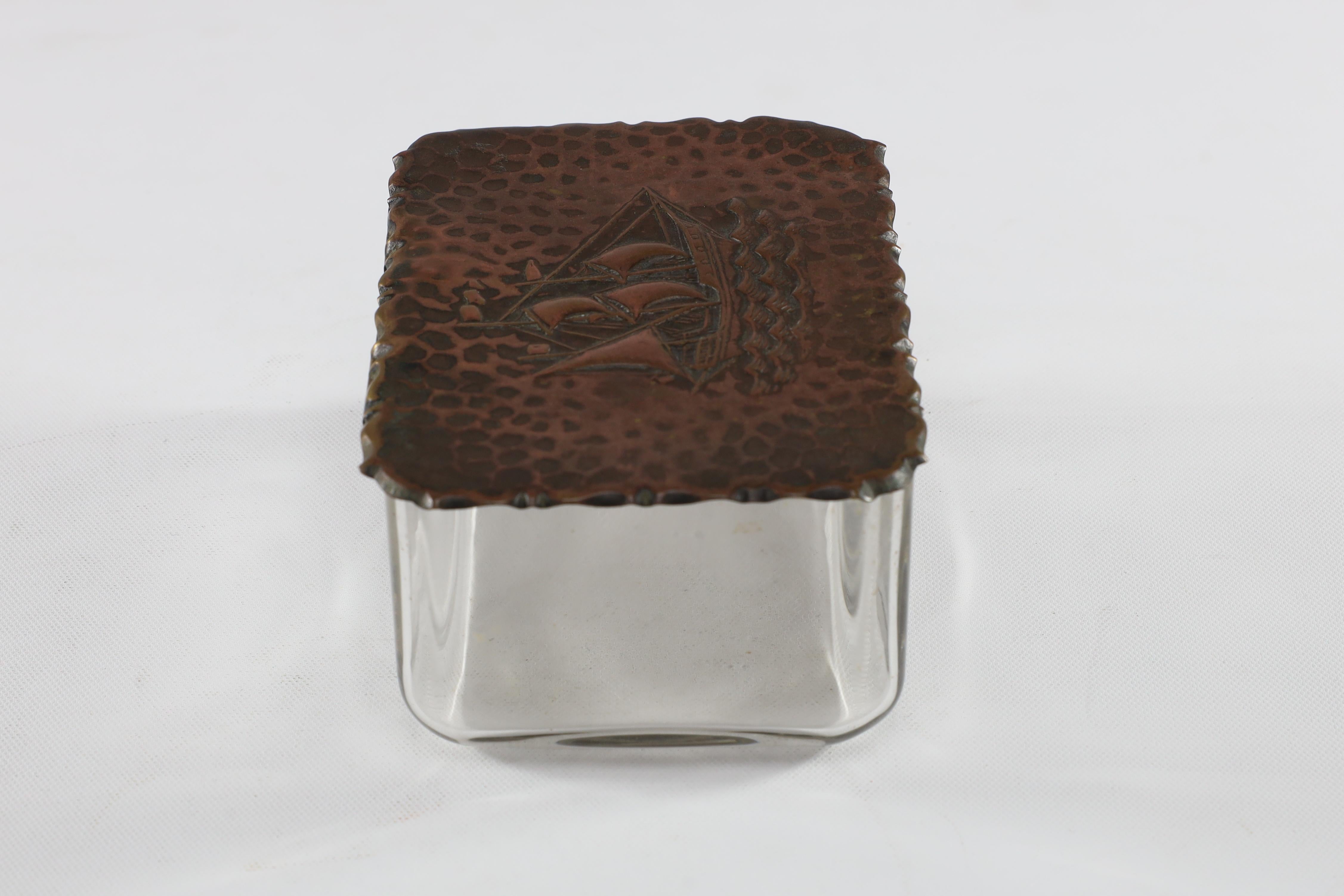 A little glass jewelry box with hand hammered ship to the copper lid.