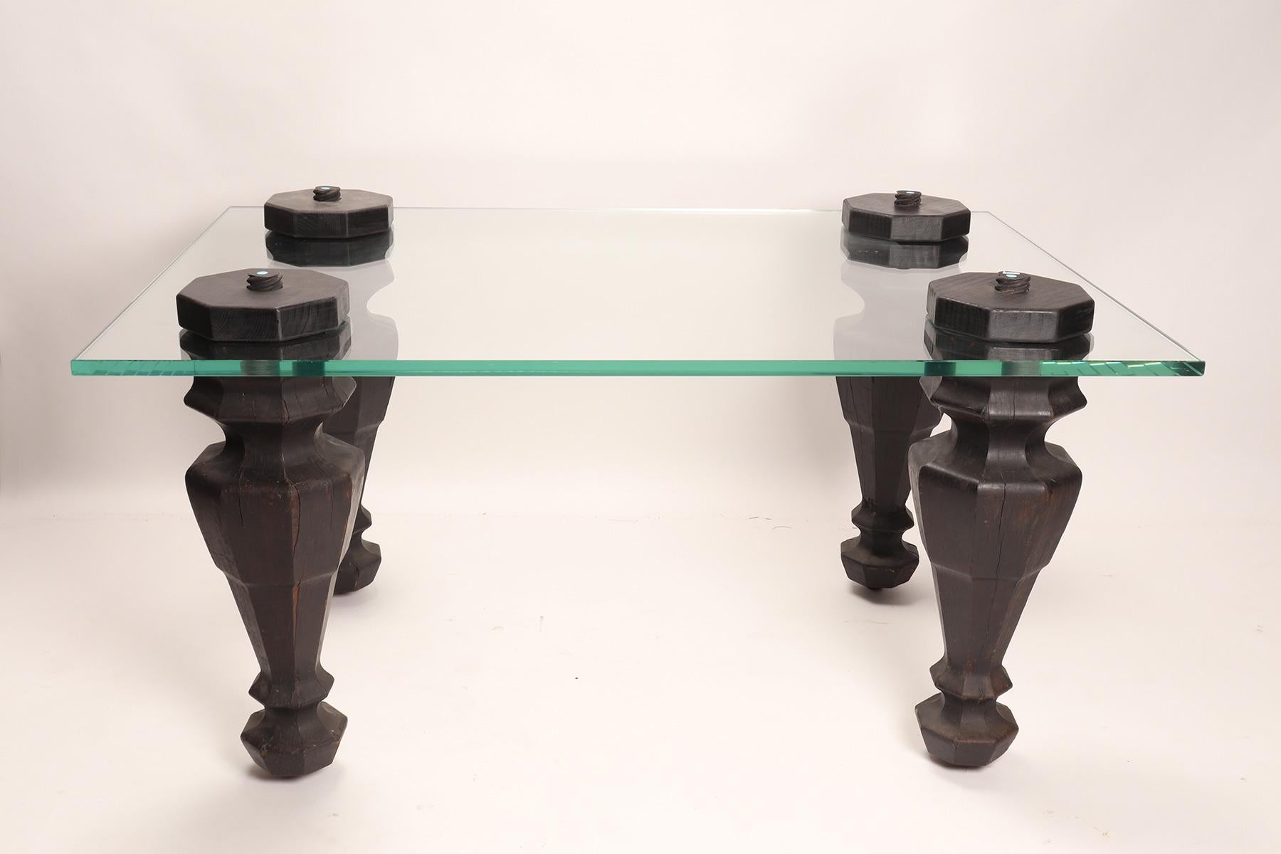 An example of reinterpretation and realization of old elements. The four wooden legs with wheels from a grand piano, were used as legs for a living room table. The table top, rectangular in shape, is made from a thick layer of glass. Italy 1970 ca.